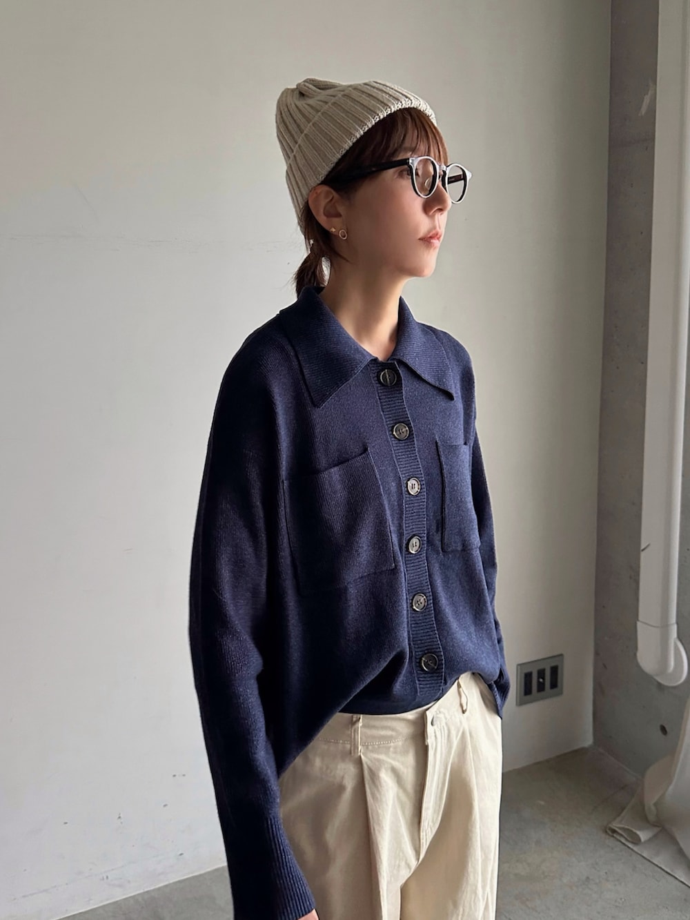 ブルー系のトップス、ブラック系のハンドバッグ、ブラック系のスニーカーを着用したレディースの秋コーディネートの3枚目の写真