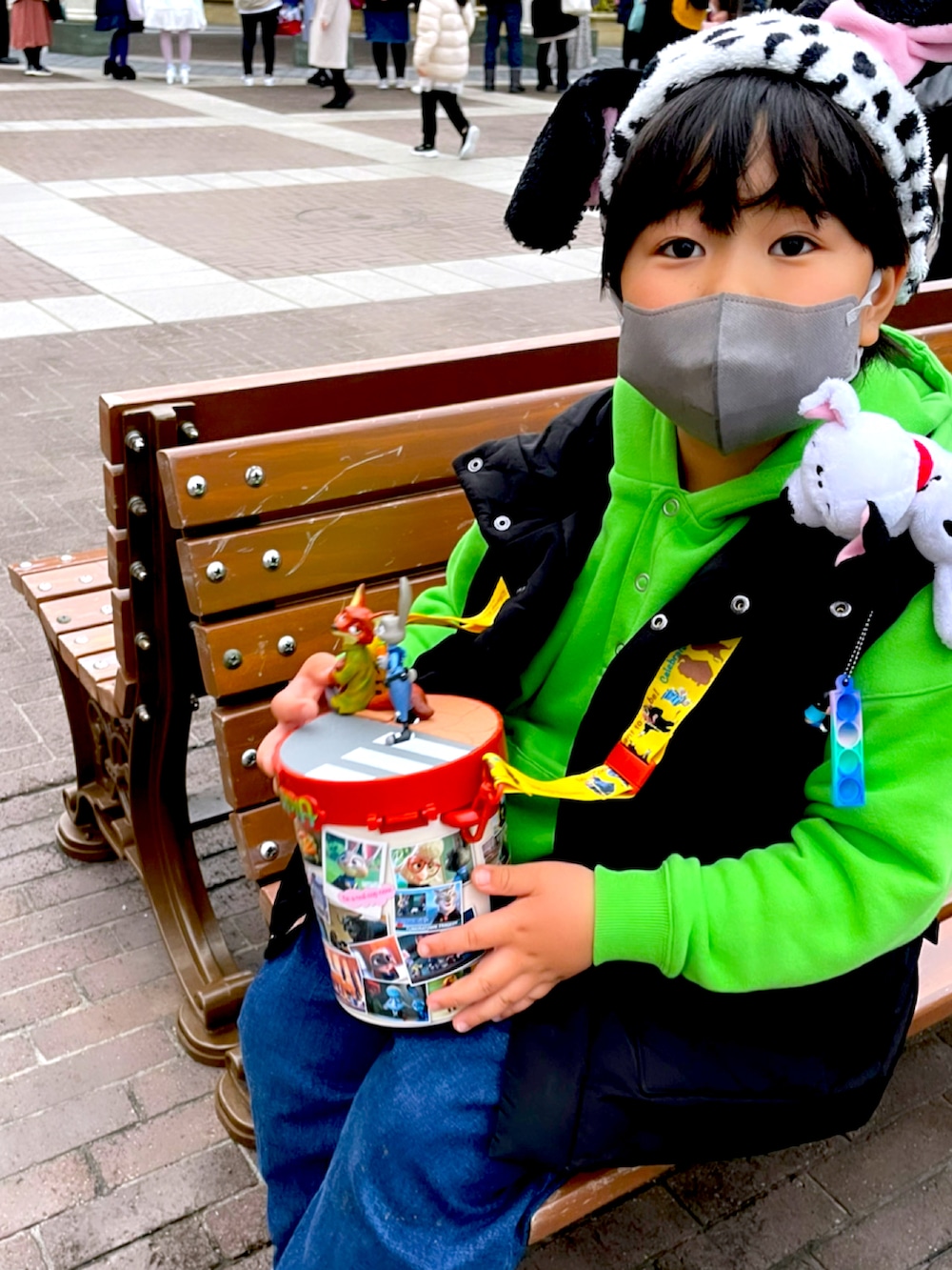 ブルー系のデニムパンツ、グリーン系のパーカー、ホワイト系のダウンベストを着用したキッズの冬コーディネートの3枚目の写真