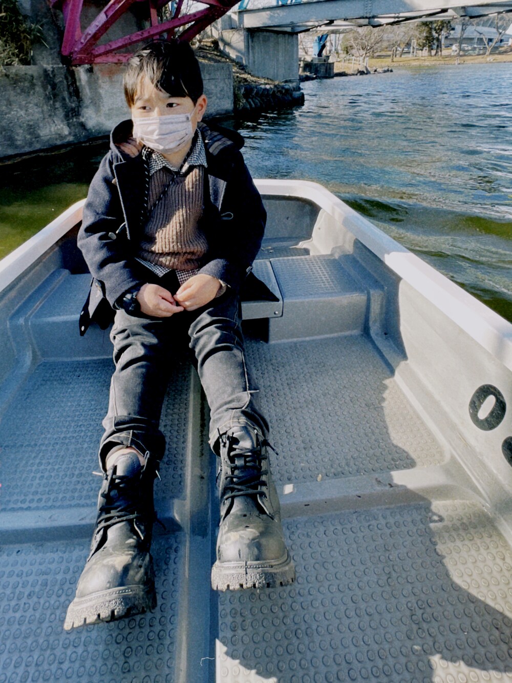 ブラック系のデニムパンツ、ブラック系のブーツ、ブラウン系のシャツ/ブラウスを着用したキッズの冬コーディネートの2枚目の写真