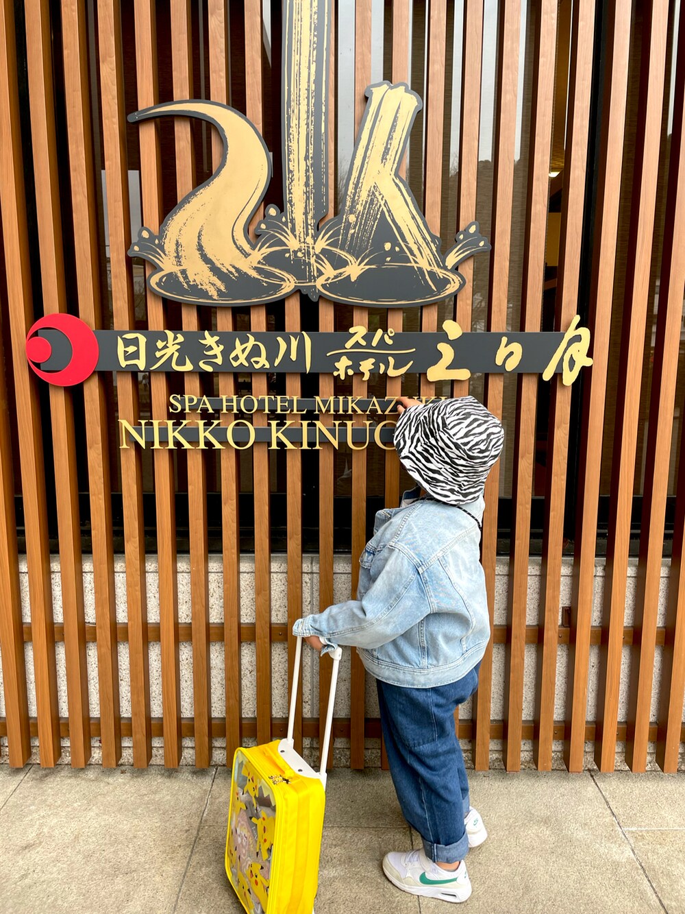 ブルー系のサロペット/オーバーオール、ホワイト系のスニーカー、ブルー系のデニムジャケットを着用したキッズの春コーディネートの3枚目の写真
