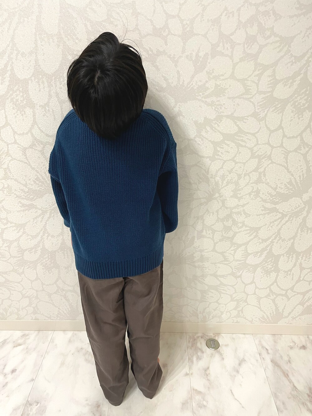 ブルー系のニット/セーター、ブラック系のダウンベスト、ブラウン系のその他パンツを着用したキッズの秋コーディネートの2枚目の写真