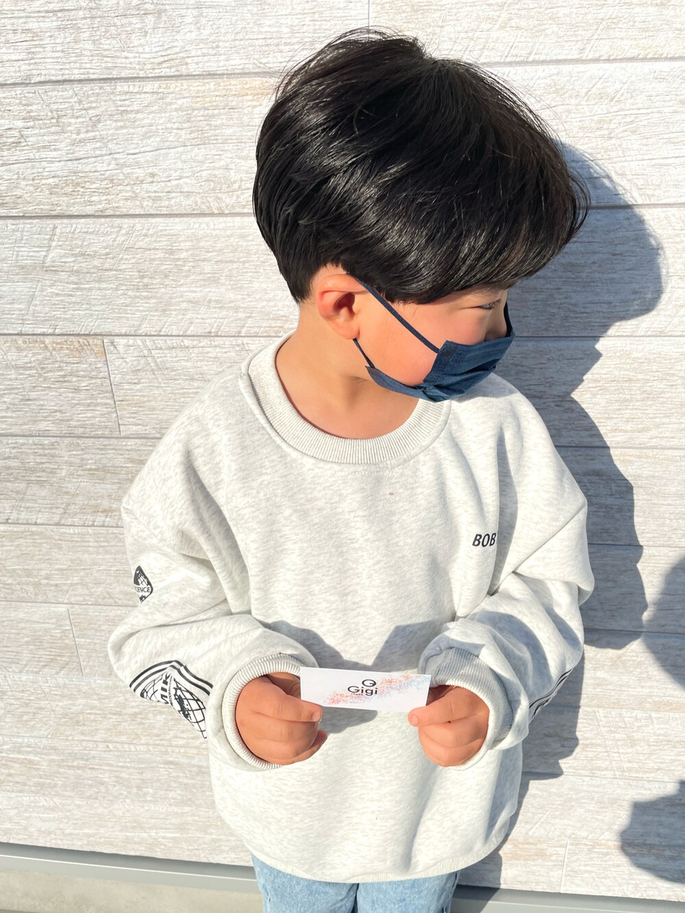 ホワイト系のスウェットを着用したキッズの冬コーディネートの2枚目の写真