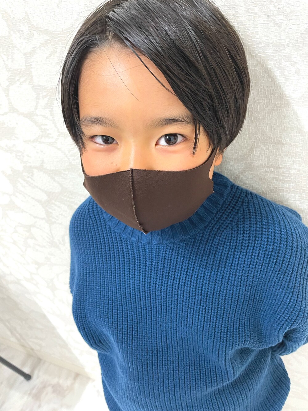 ブルー系のニット/セーター、ブラック系のダウンベスト、ブラウン系のその他パンツを着用したキッズの秋コーディネートの4枚目の写真