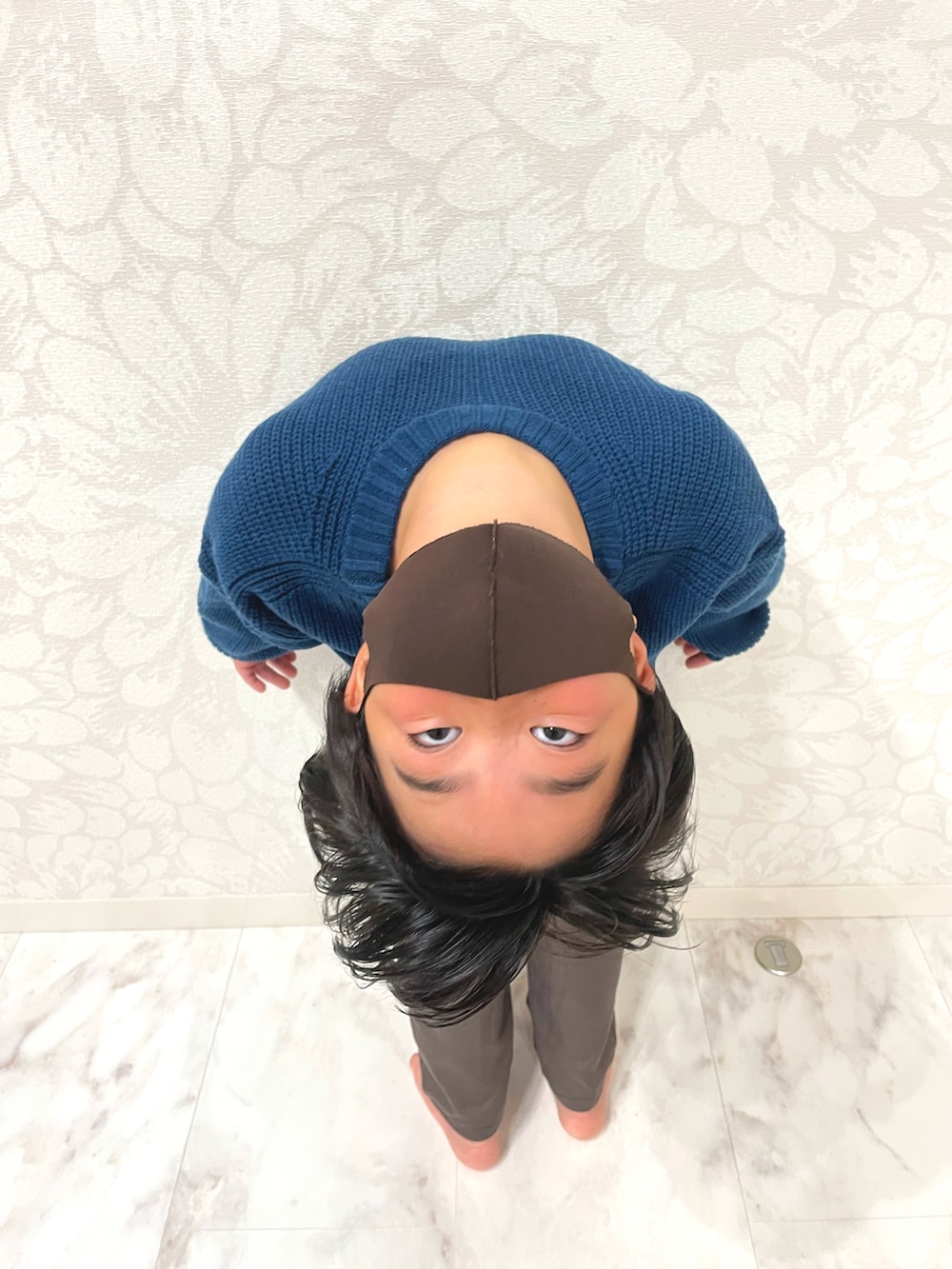 ブルー系のニット/セーター、ブラック系のダウンベスト、ブラウン系のその他パンツを着用したキッズの秋コーディネートの3枚目の写真