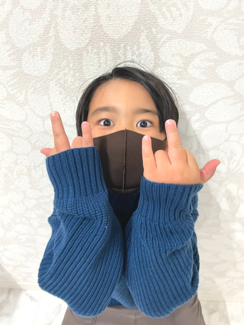 ブルー系のニット/セーター、ブラック系のダウンベスト、ブラウン系のその他パンツを着用したキッズの秋コーディネートの5枚目の写真