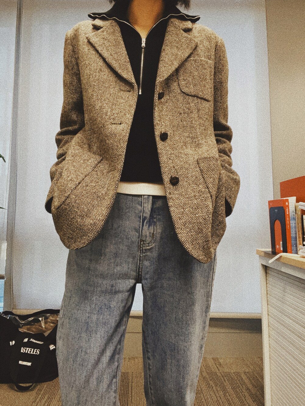 ブラウン系のテーラードジャケット、ブルー系のデニムパンツ、ブラック系のスリッポンを着用したレディースの秋コーディネートの2枚目の写真