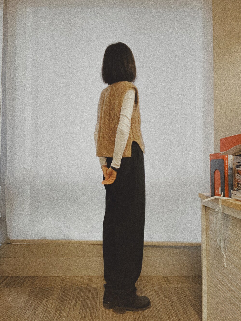 ベージュ系のタンクトップ、ブラック系のスラックスを着用したレディースの秋コーディネートの2枚目の写真