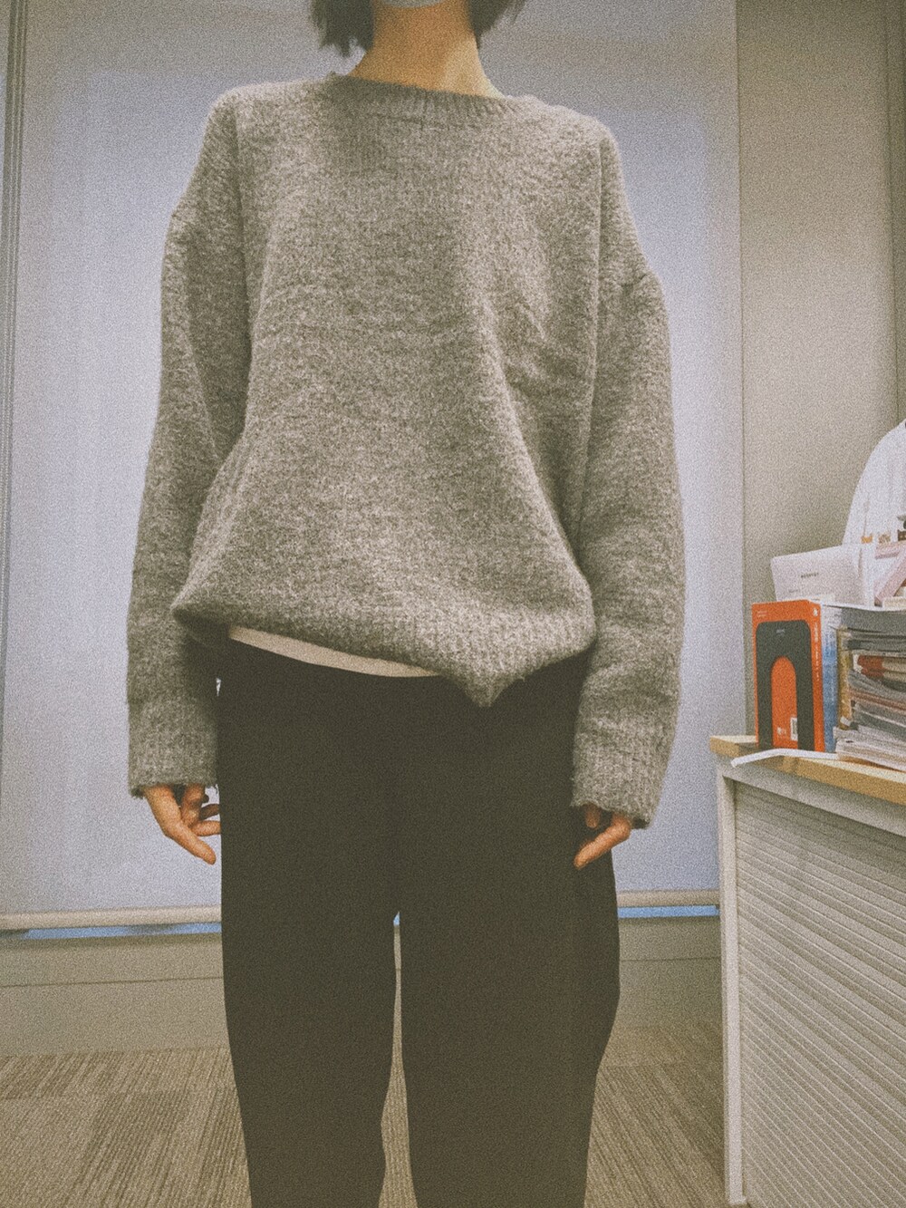 グレー系のニット/セーター、ホワイト系のタンクトップ、ブラック系のスラックスを着用したレディースの秋コーディネートの3枚目の写真