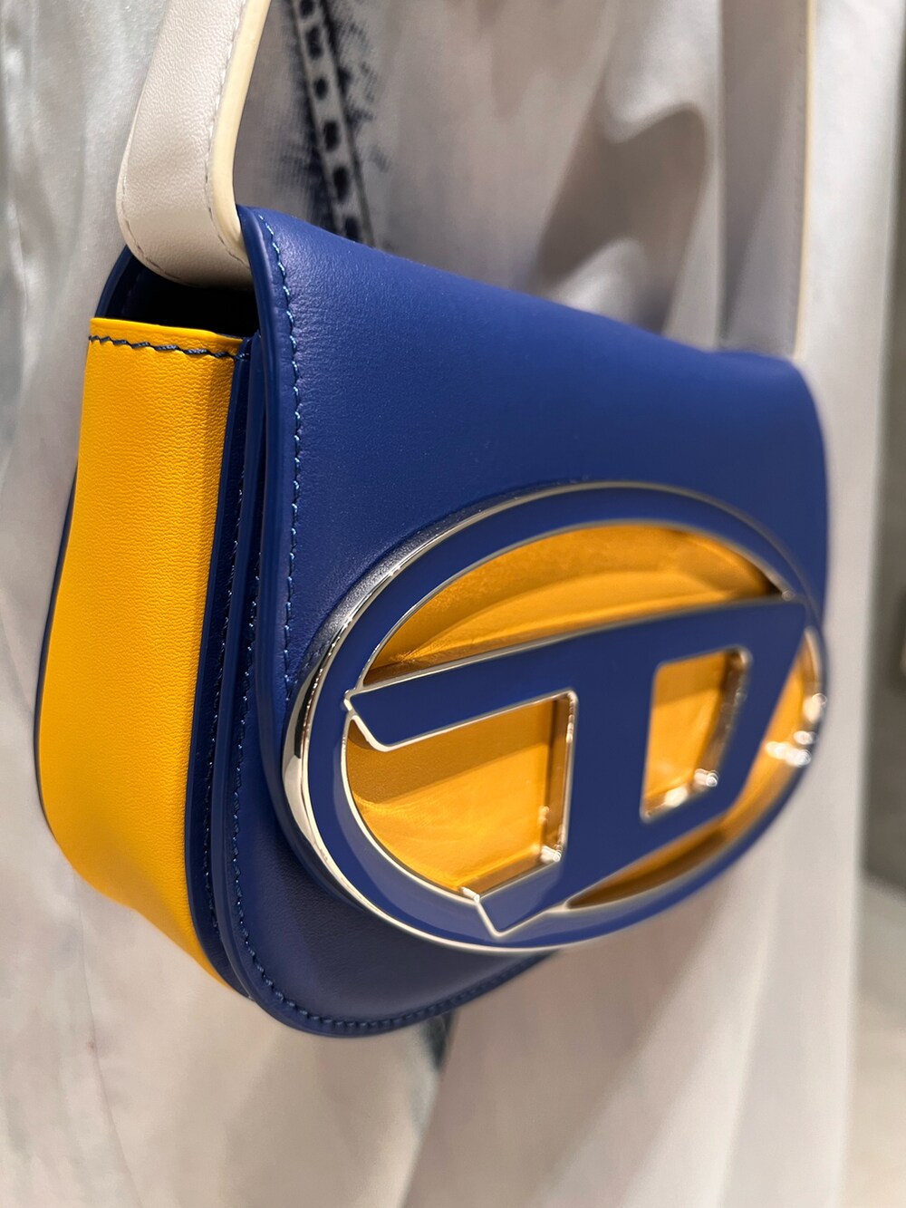 ブルー系のショルダーバッグ、ブルー系のスカート、ブルー系のTシャツ/カットソーを着用したレディースの夏コーディネートの5枚目の写真