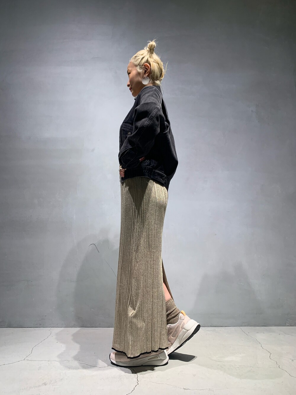 ピンク系のスニーカー、ゴールド系のワンピース、ベージュ系のTシャツ/カットソーを着用したレディースの春コーディネートの2枚目の写真