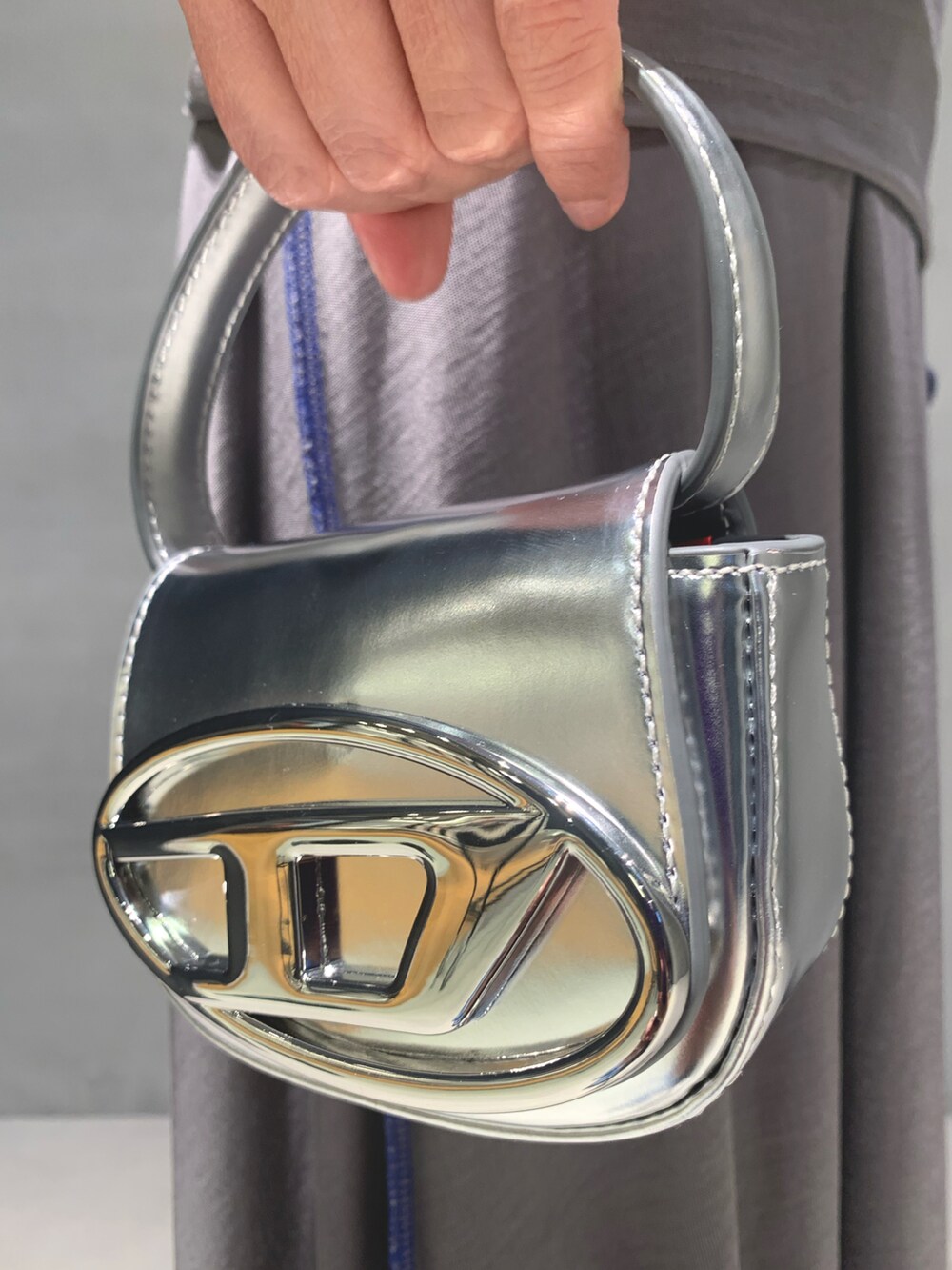 ブラック系のサンダル、グレー系のスカート、シルバー系のチューブトップを着用したレディースの夏コーディネートの2枚目の写真