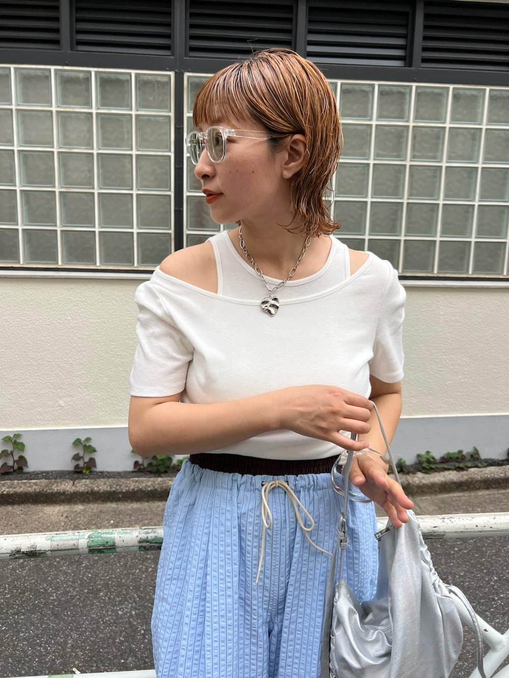 ホワイト系のTシャツ/カットソー、ブルー系のパンツ、シルバー系のショルダーバッグを着用したレディースの春コーディネートの2枚目の写真