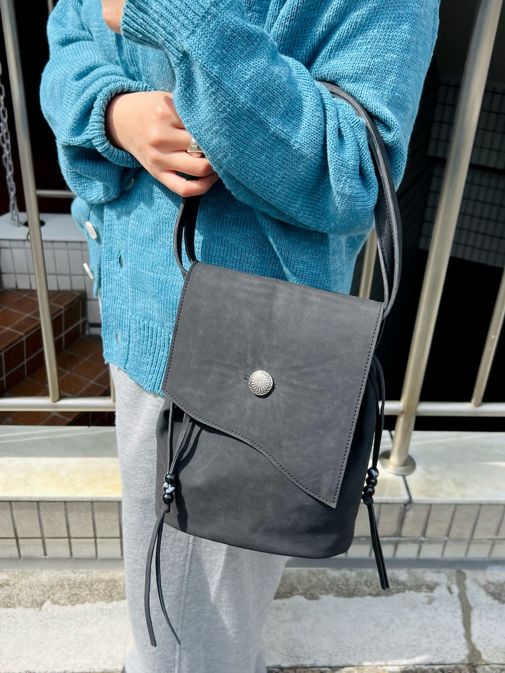グレー系のスウェットパンツ、ブルー系のカーディガン/ボレロを着用したレディースの春コーディネートの3枚目の写真