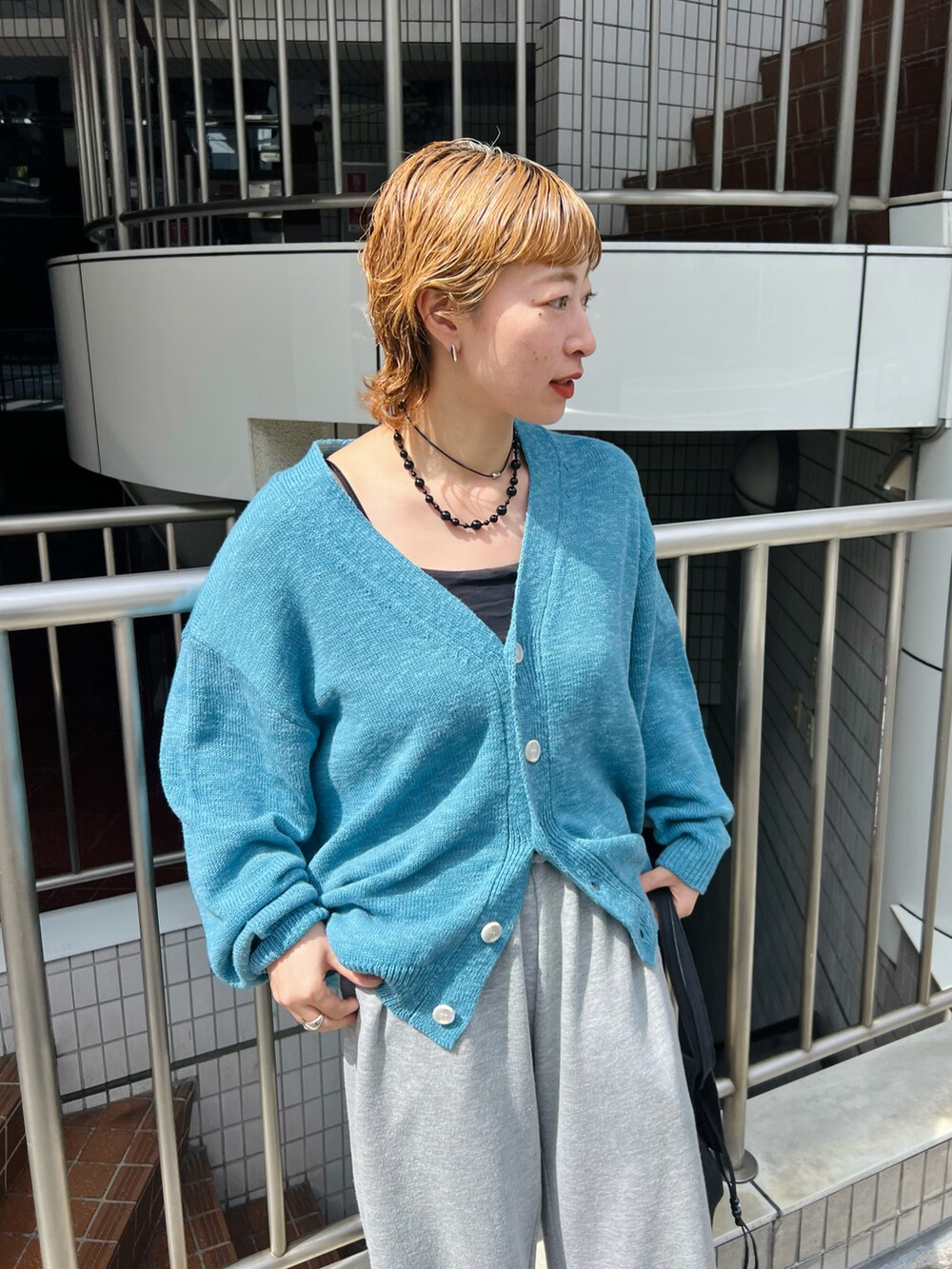 グレー系のスウェットパンツ、ブルー系のカーディガン/ボレロを着用したレディースの春コーディネートの2枚目の写真