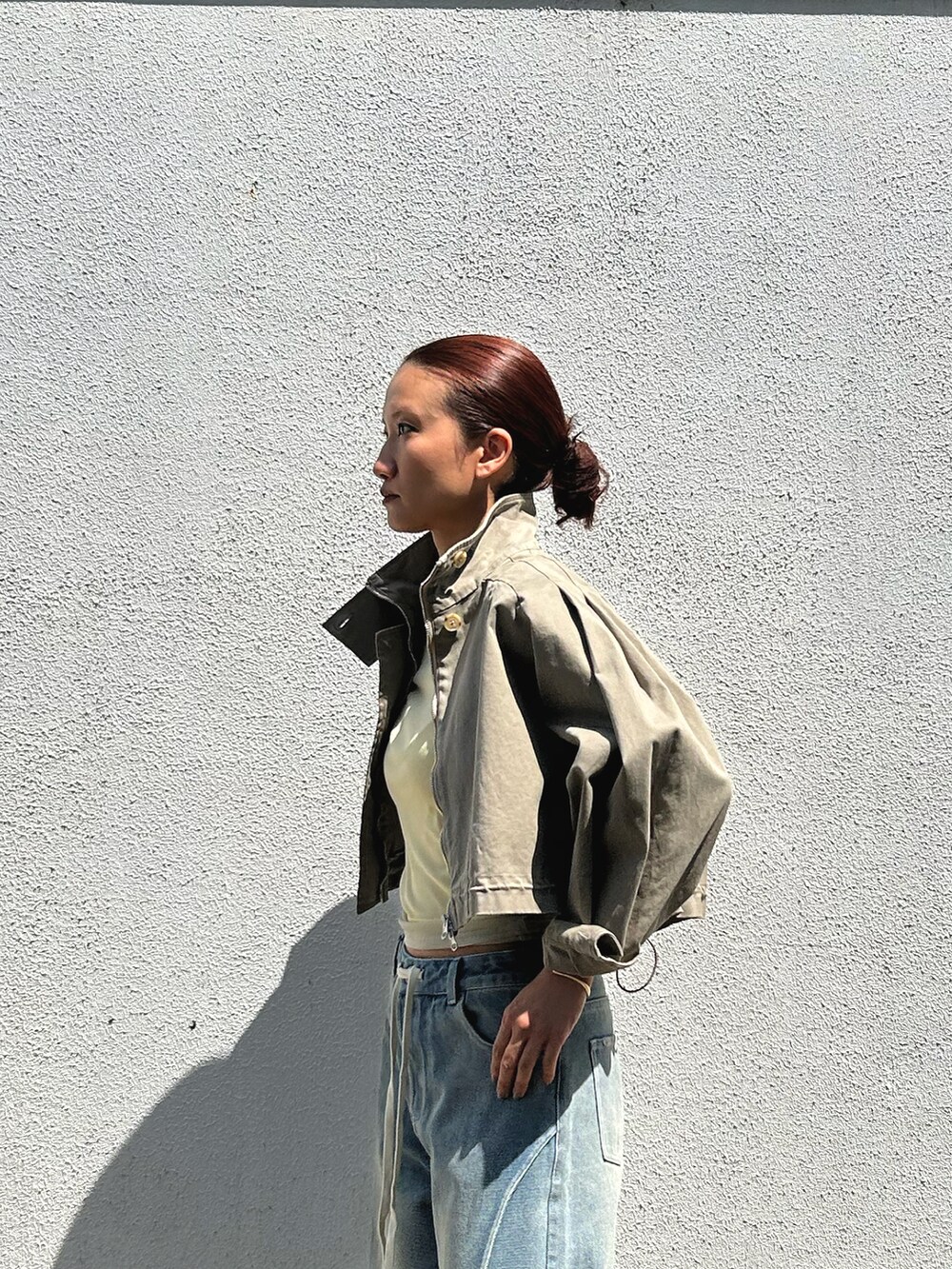 ブルー系のデニムパンツ、ベージュ系のミリタリージャケット、イエロー系のTシャツ/カットソーを着用したレディースの春コーディネートの3枚目の写真