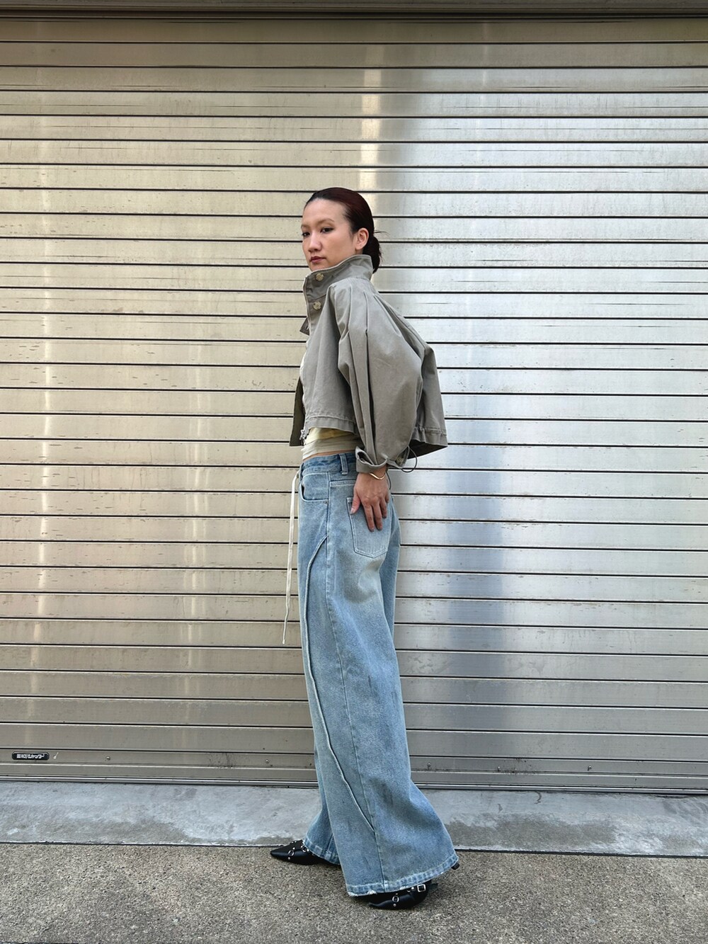 ブルー系のデニムパンツ、ベージュ系のミリタリージャケット、イエロー系のTシャツ/カットソーを着用したレディースの春コーディネートの2枚目の写真