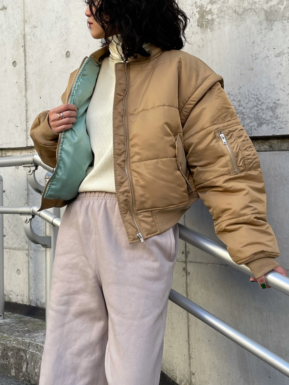 ホワイト系のニット/セーター、ベージュ系のMA-1、ベージュ系のパンツを着用したレディースの秋コーディネートの2枚目の写真