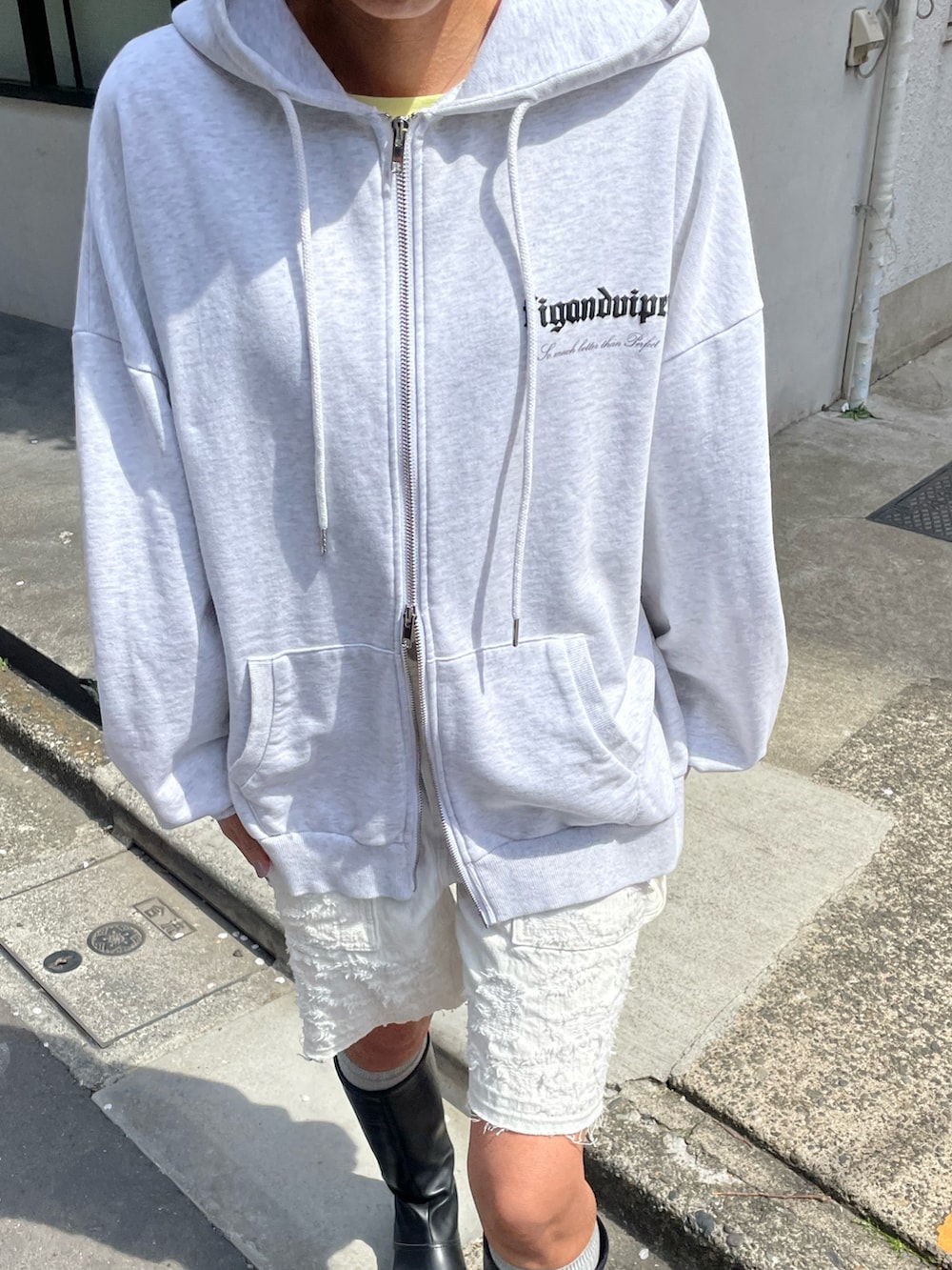 ホワイト系のパーカー、ホワイト系のデニムパンツ、ブラック系のブーツを着用したレディースの春コーディネートの5枚目の写真