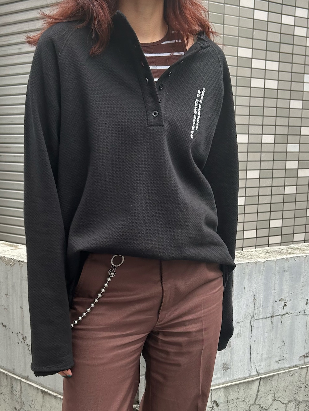 ブラック系のTシャツ/カットソー、ブラウン系のスラックス、ブラウン系のブーツを着用したレディースの春コーディネートの3枚目の写真