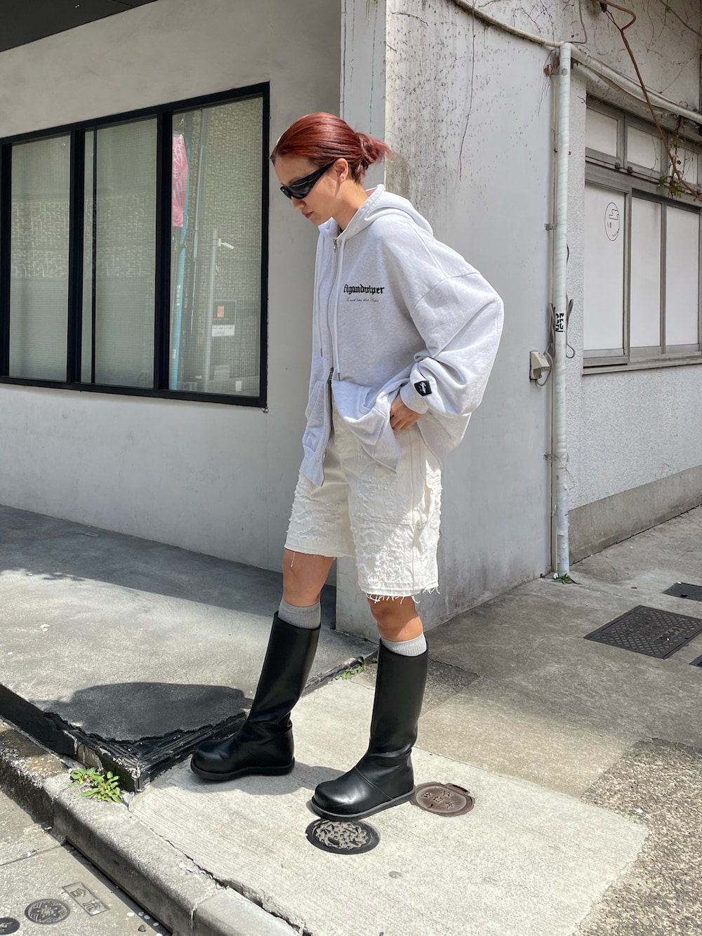 ホワイト系のパーカー、ホワイト系のデニムパンツ、ブラック系のブーツを着用したレディースの春コーディネートの3枚目の写真