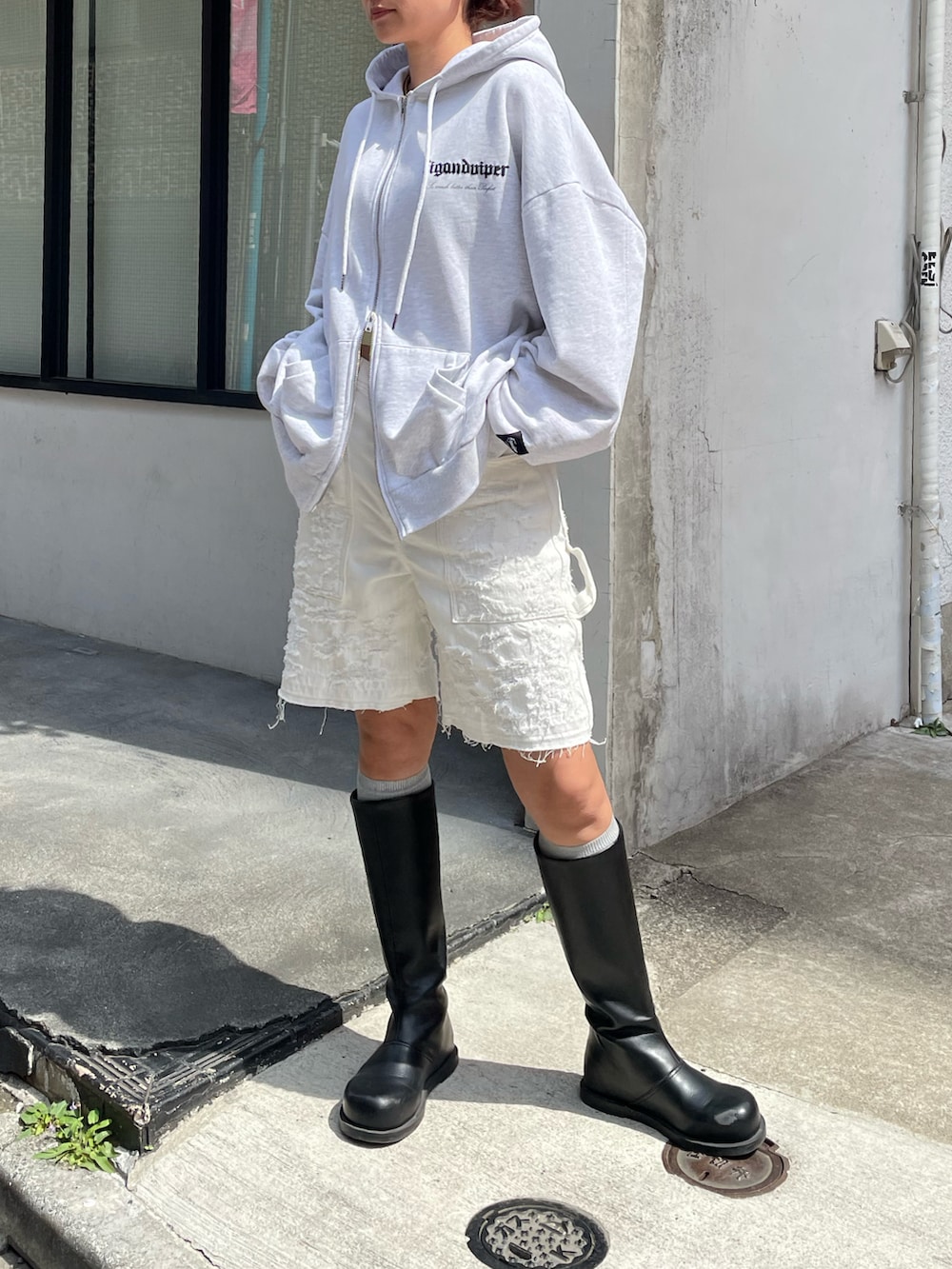 ホワイト系のパーカー、ホワイト系のデニムパンツ、ブラック系のブーツを着用したレディースの春コーディネートの4枚目の写真