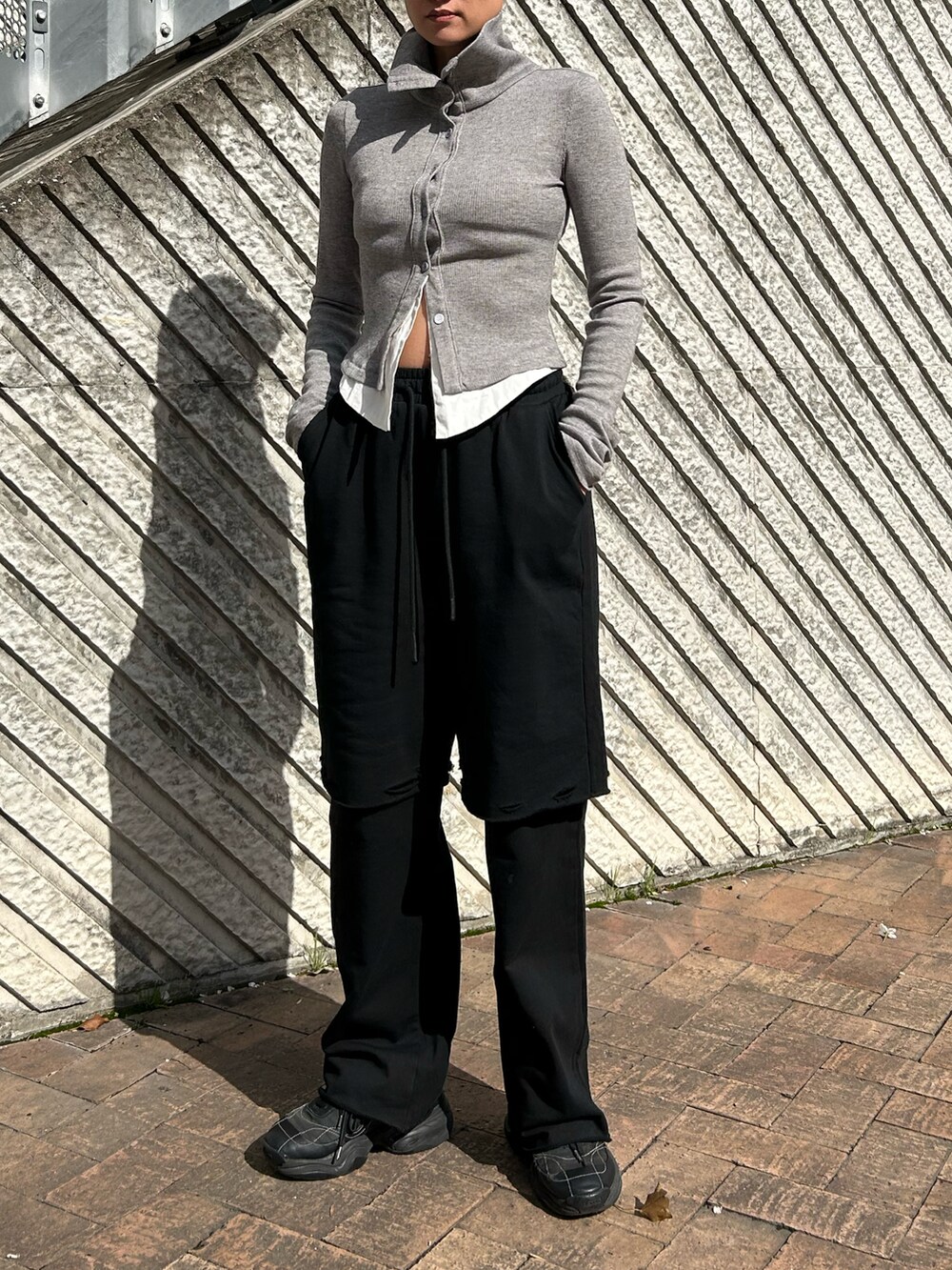 グレー系のシャツ/ブラウス、ブラック系のスウェットパンツを着用したレディースの春コーディネートの2枚目の写真