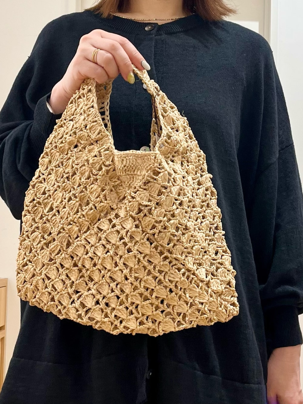 ブラック系のカーディガン/ボレロ、ベージュ系のハンドバッグ、ブラック系のサンダルを着用したレディースの夏コーディネートの4枚目の写真