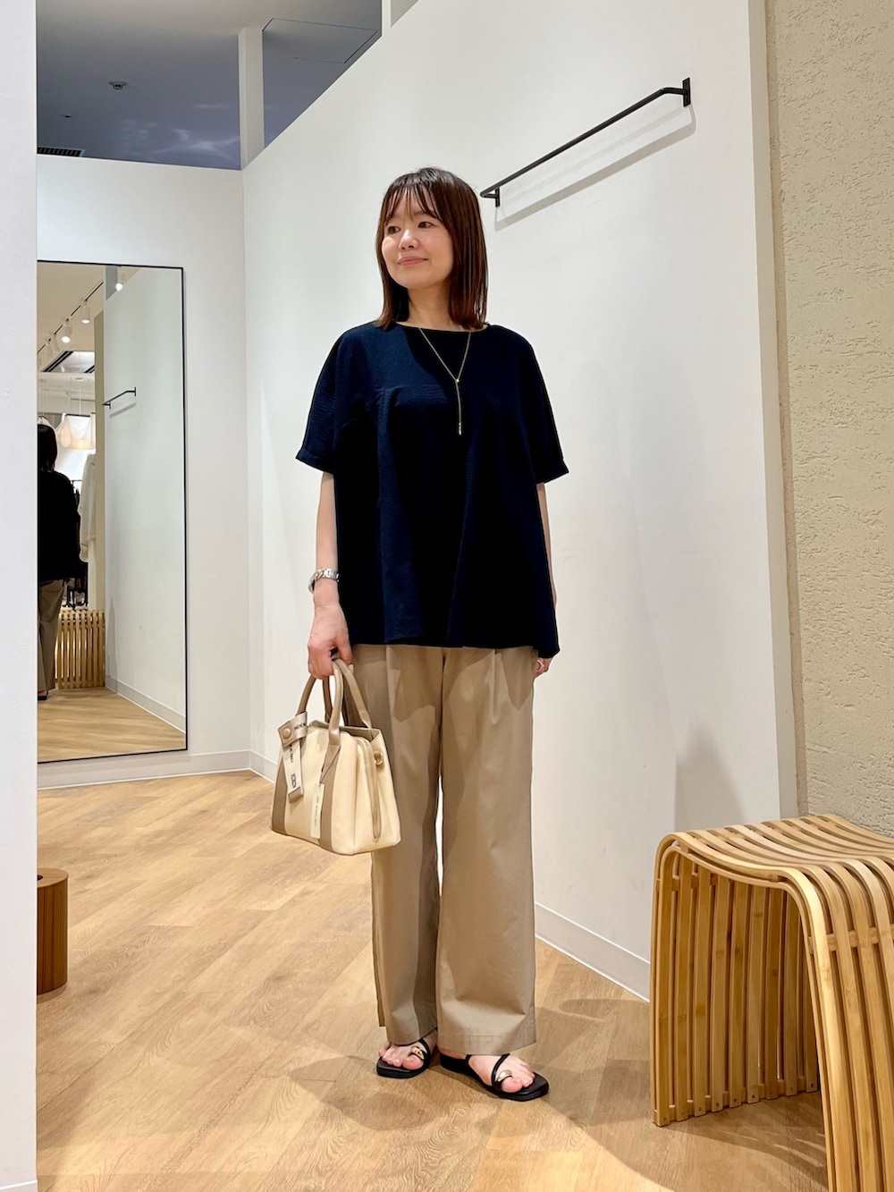 ベージュ系のその他パンツ、ホワイト系のハンドバッグ、ブルー系のシャツ/ブラウスを着用したレディースの夏コーディネートの2枚目の写真