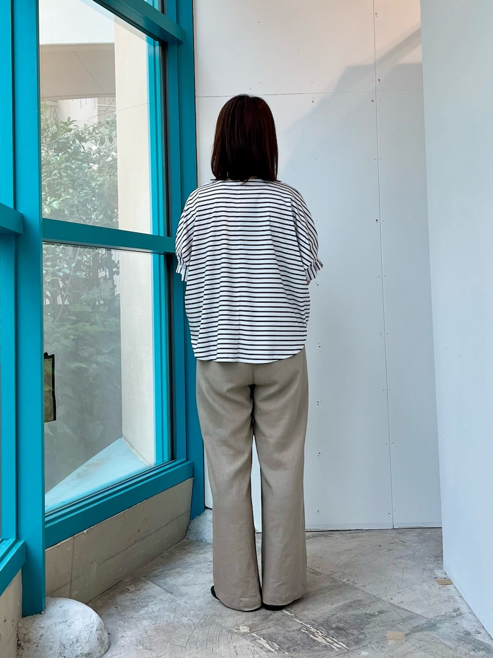 ホワイト系のTシャツ/カットソー、ベージュ系のその他パンツ、ブラック系のショルダーバッグを着用したレディースの夏コーディネートの3枚目の写真