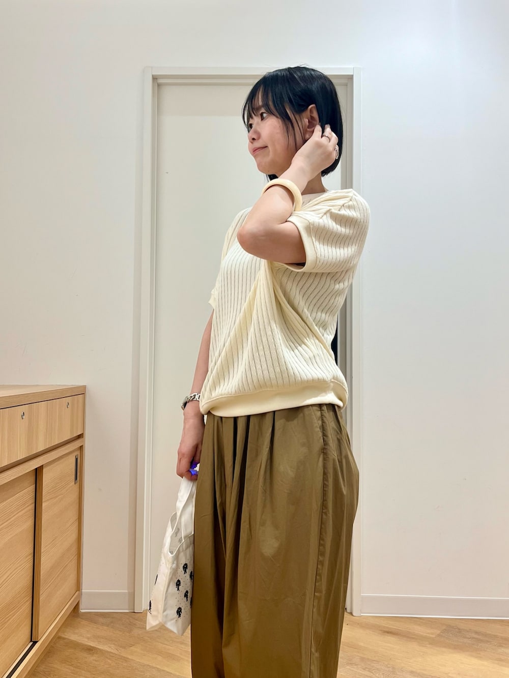 ホワイト系のTシャツ/カットソー、ベージュ系のその他パンツ、ブラウン系のサンダルを着用したレディースの夏コーディネートの3枚目の写真