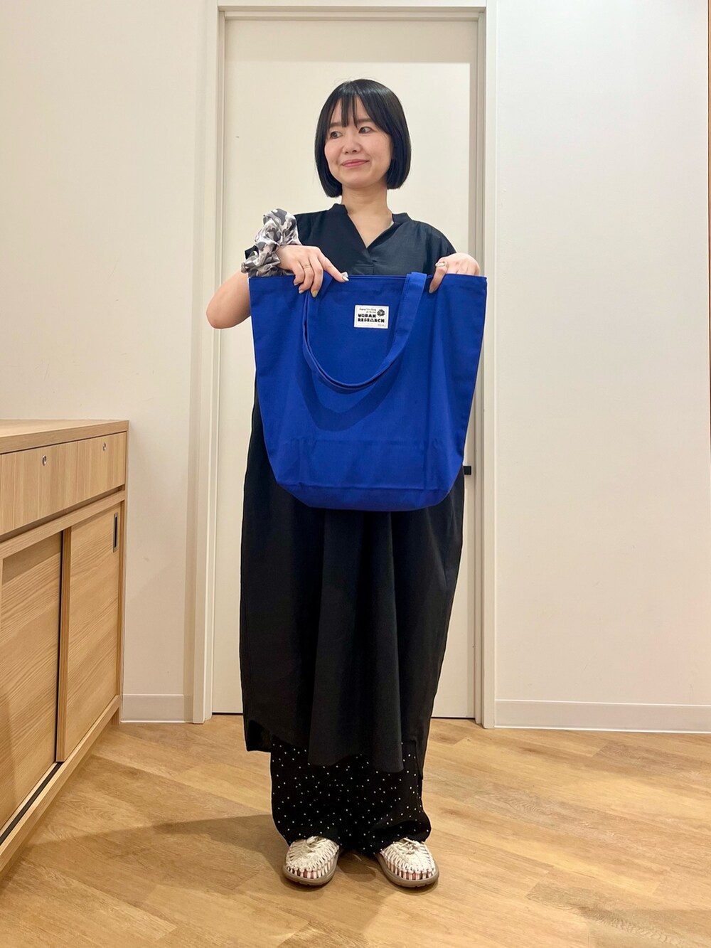 ブラック系のワンピース、ブルー系のトートバッグ、ブルー系のその他パンツを着用したレディースの夏コーディネートの4枚目の写真