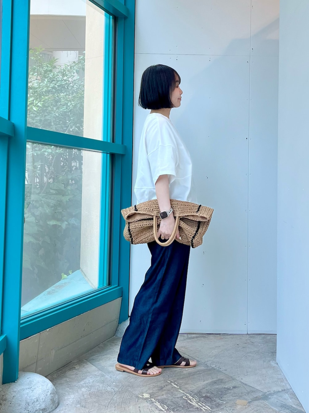 ホワイト系のTシャツ/カットソー、ブルー系のデニムパンツ、ベージュ系のトートバッグを着用したレディースの夏コーディネートの4枚目の写真
