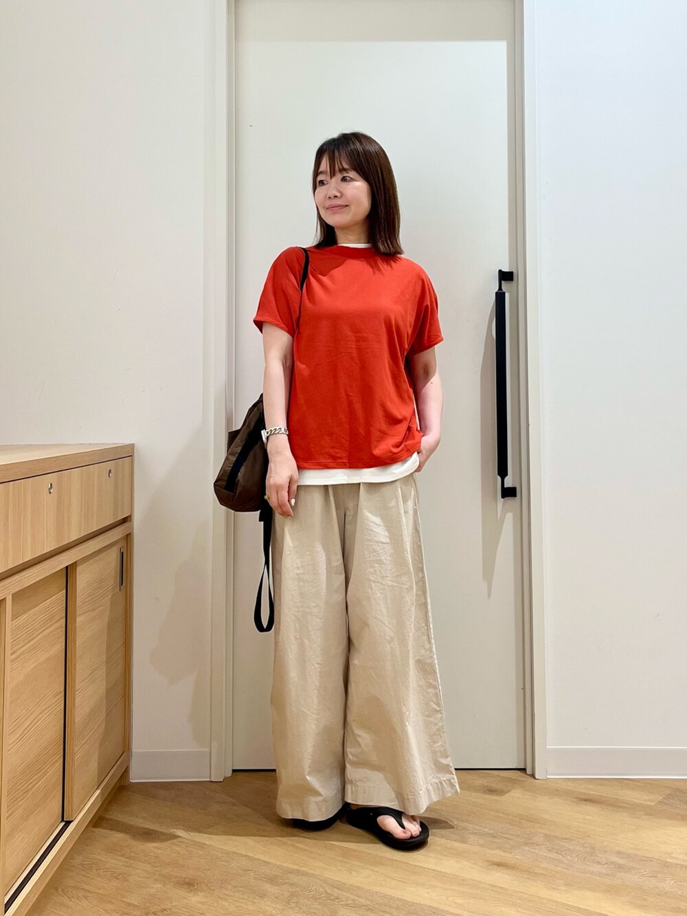 レッド系のTシャツ/カットソー、ホワイト系のTシャツ/カットソー、ブラウン系のショルダーバッグを着用したレディースの夏コーディネートの4枚目の写真