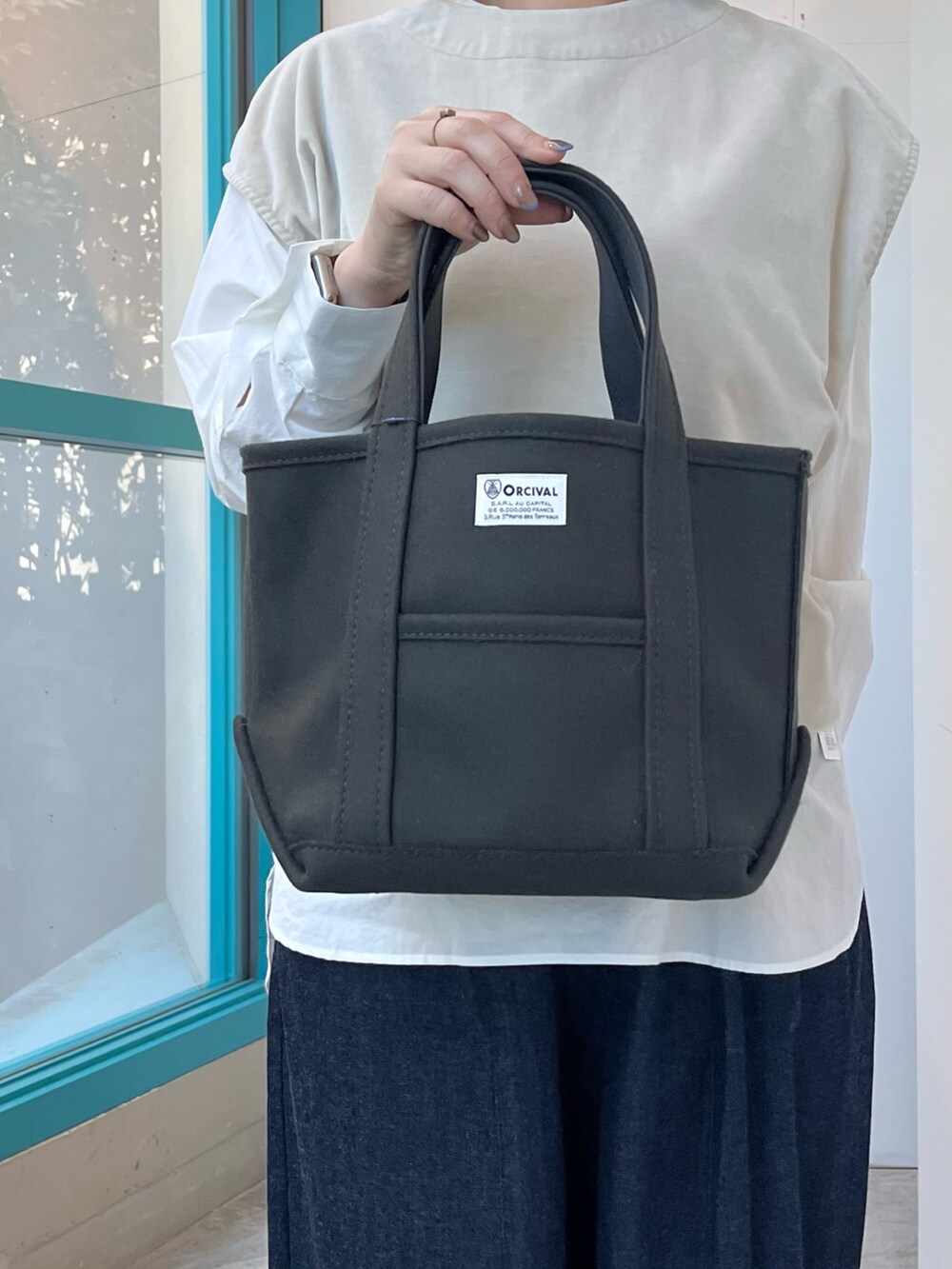 グレー系のベスト、ホワイト系のシャツ/ブラウス、ブラック系のサンダルを着用したレディースの秋コーディネートの4枚目の写真