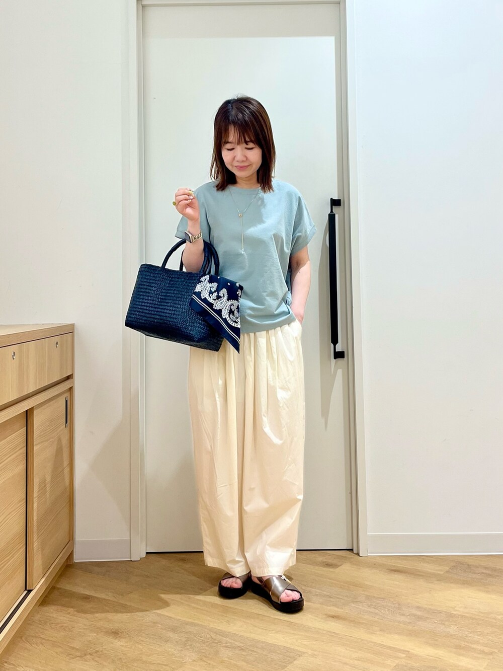 グリーン系のTシャツ/カットソー、ホワイト系のその他パンツ、ブルー系のトートバッグを着用したレディースの夏コーディネートの3枚目の写真