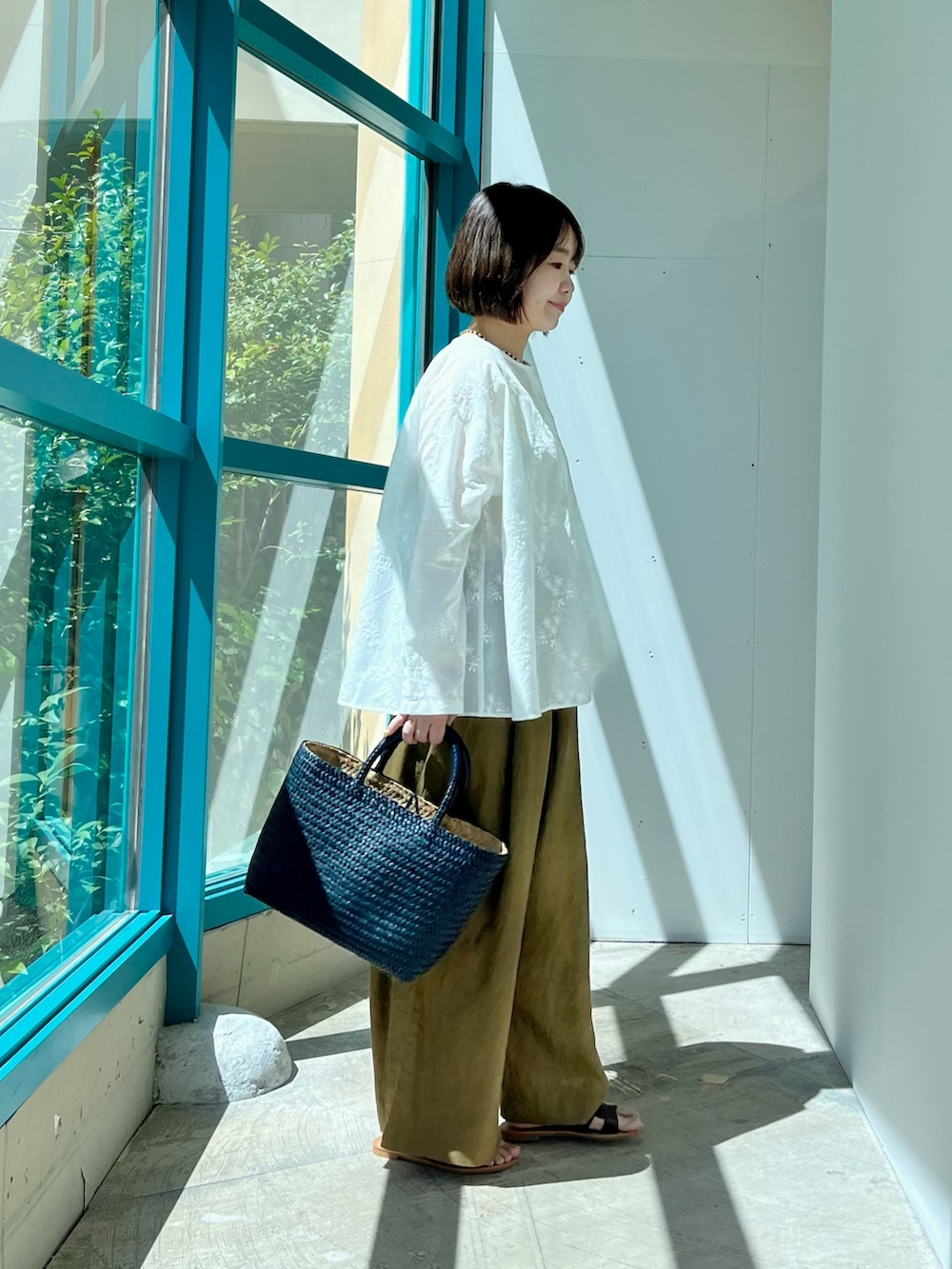 ホワイト系のシャツ/ブラウス、ベージュ系のその他パンツ、ブルー系のトートバッグを着用したレディースの夏コーディネートの2枚目の写真