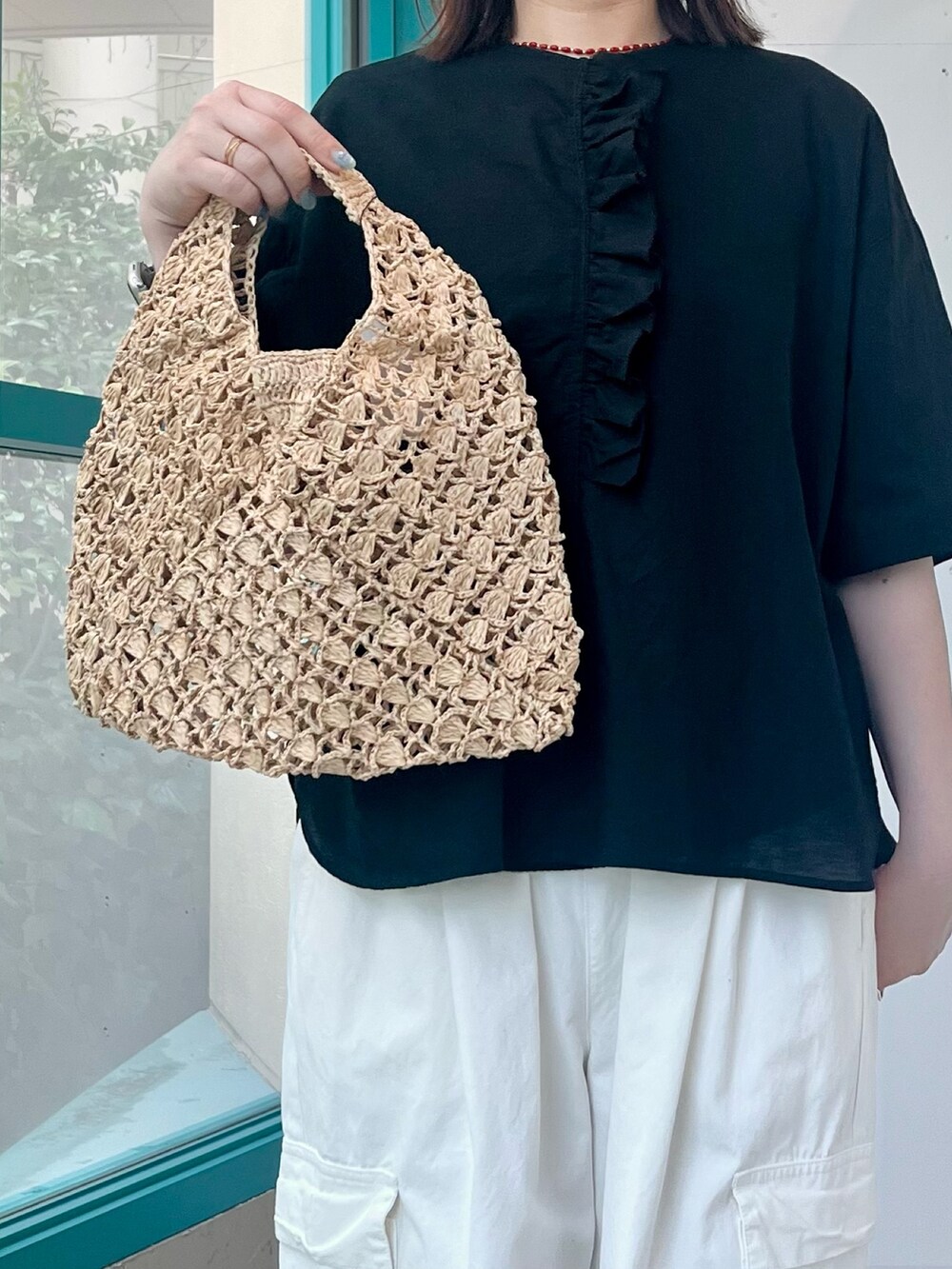 ブラック系のシャツ/ブラウス、ホワイト系のその他パンツ、ベージュ系のハンドバッグを着用したレディースの夏コーディネートの4枚目の写真