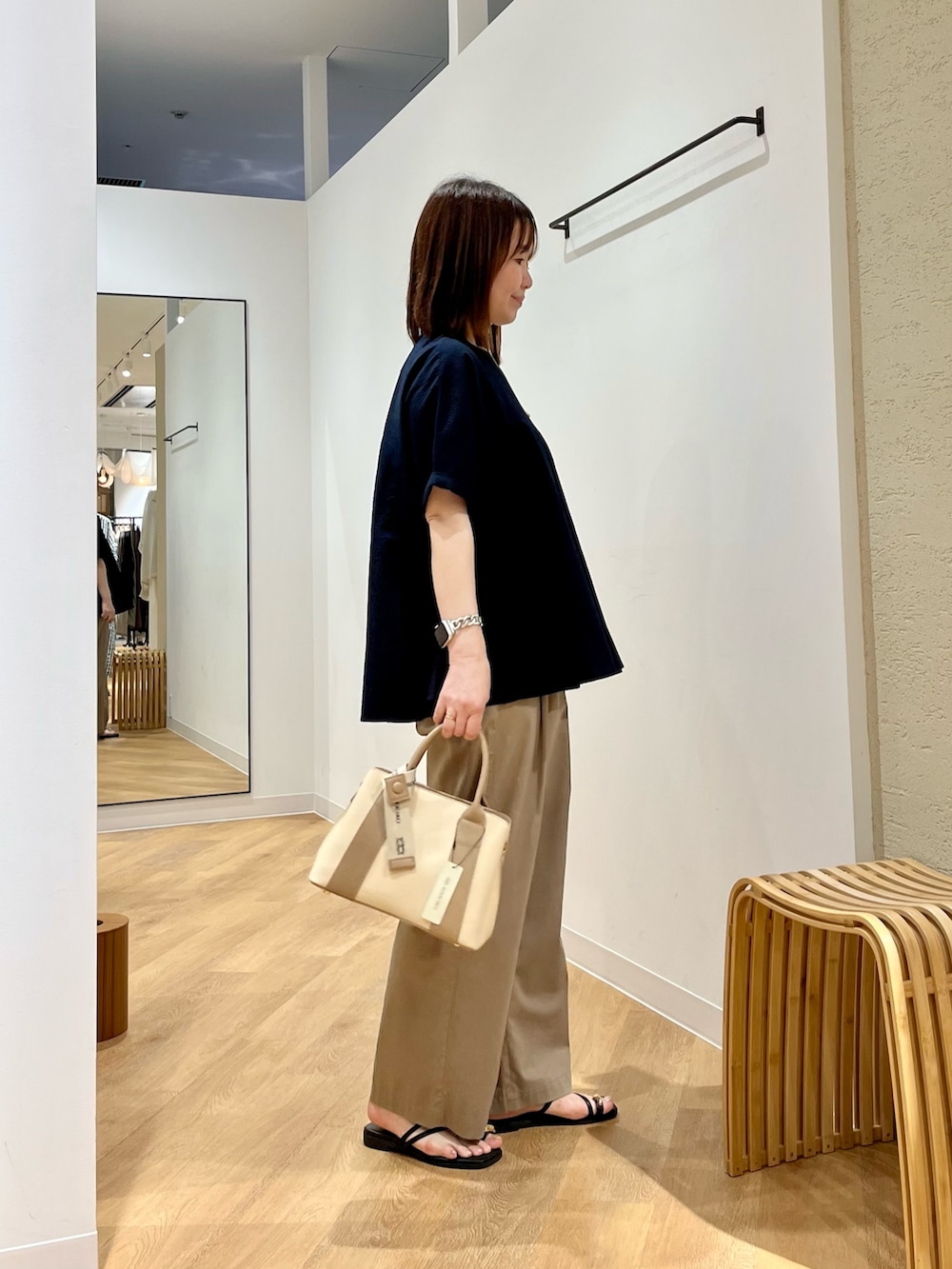 ベージュ系のその他パンツ、ホワイト系のハンドバッグ、ブルー系のシャツ/ブラウスを着用したレディースの夏コーディネートの3枚目の写真