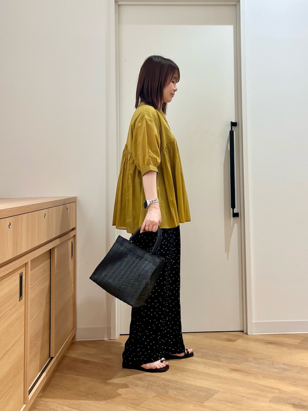 イエロー系のシャツ/ブラウス、ブラック系のその他パンツ、ブラック系のハンドバッグを着用したレディースの夏コーディネートの2枚目の写真