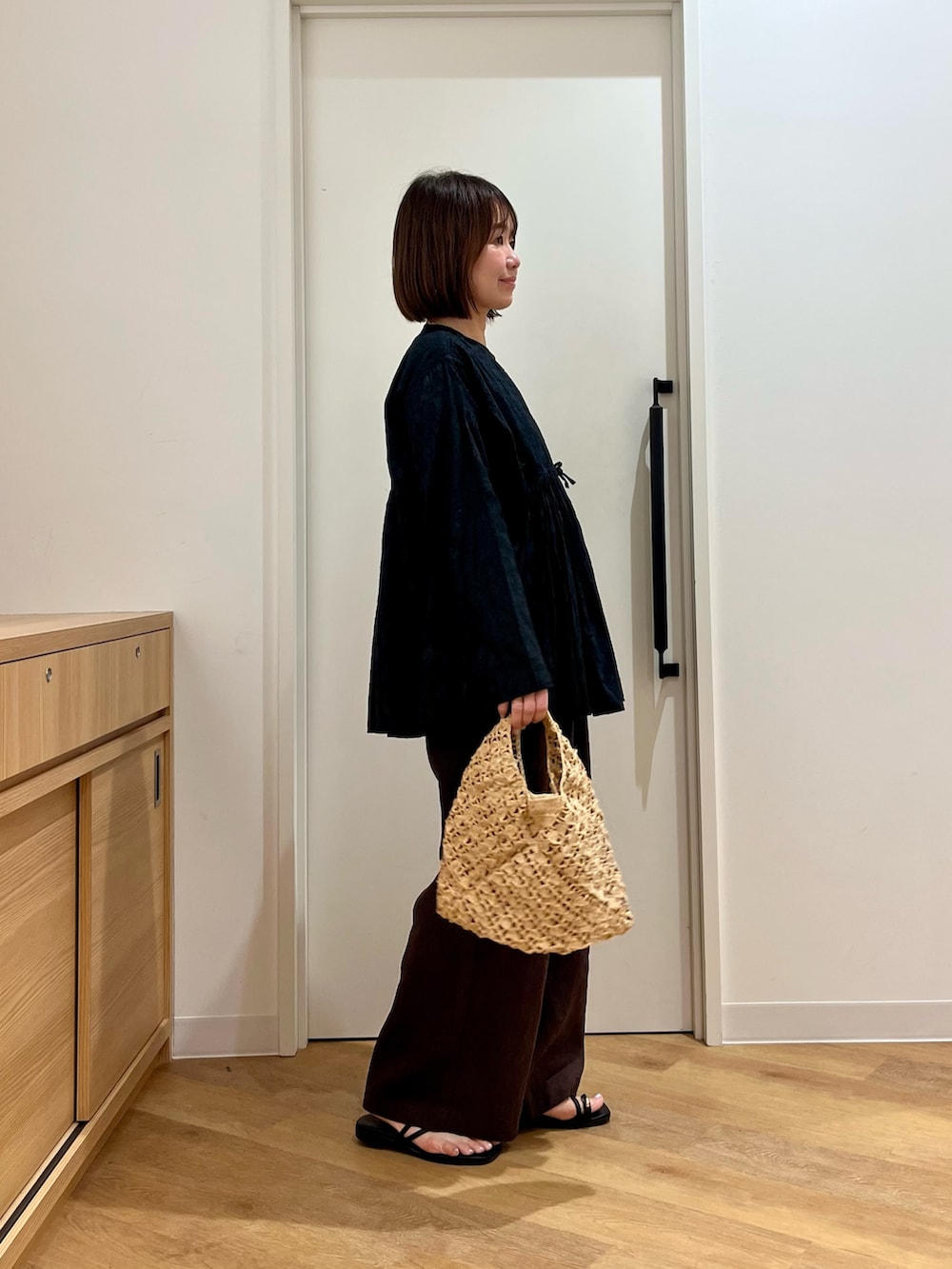 ブラック系のシャツ/ブラウス、ベージュ系のハンドバッグ、ブラウン系のその他パンツを着用したレディースの夏コーディネートの2枚目の写真