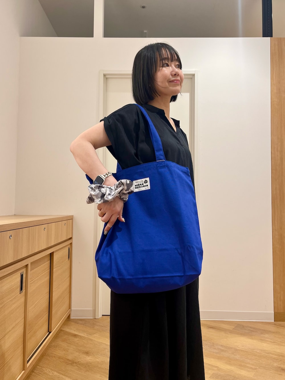ブラック系のワンピース、ブルー系のトートバッグ、ブルー系のその他パンツを着用したレディースの夏コーディネートの3枚目の写真