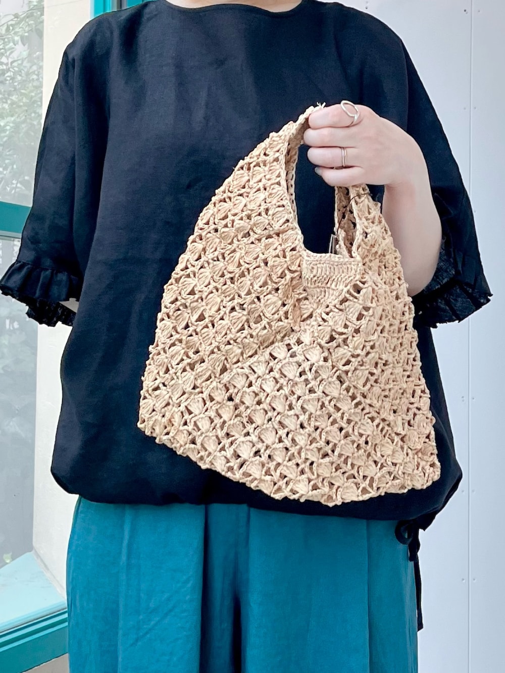 ブラック系のシャツ/ブラウス、ブルー系のその他パンツ、ベージュ系のハンドバッグを着用したレディースの夏コーディネートの5枚目の写真