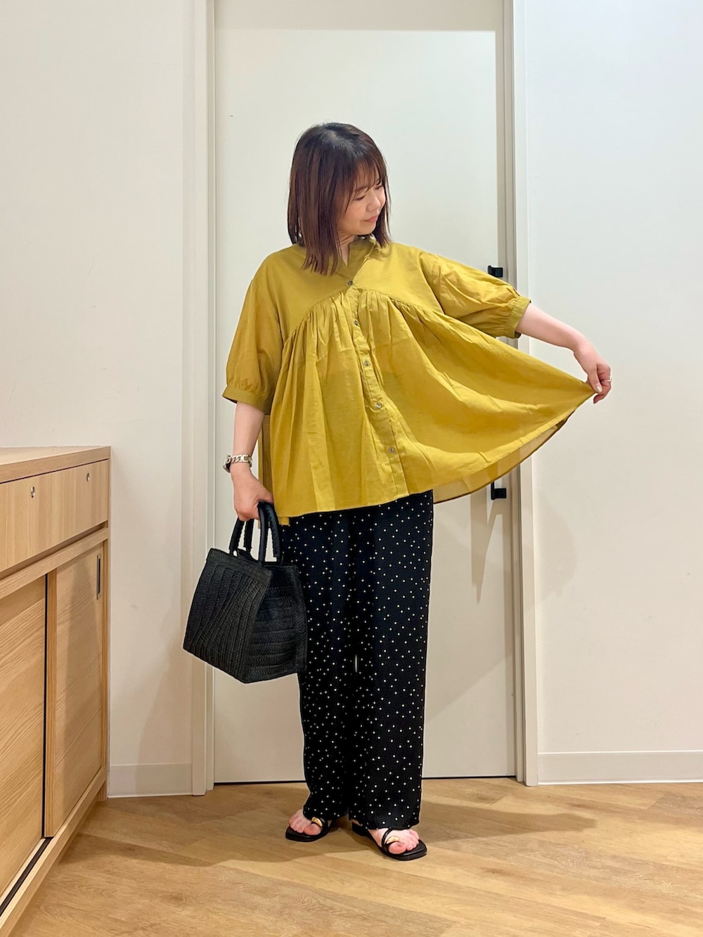 イエロー系のシャツ/ブラウス、ブラック系のその他パンツ、ブラック系のハンドバッグを着用したレディースの夏コーディネートの3枚目の写真