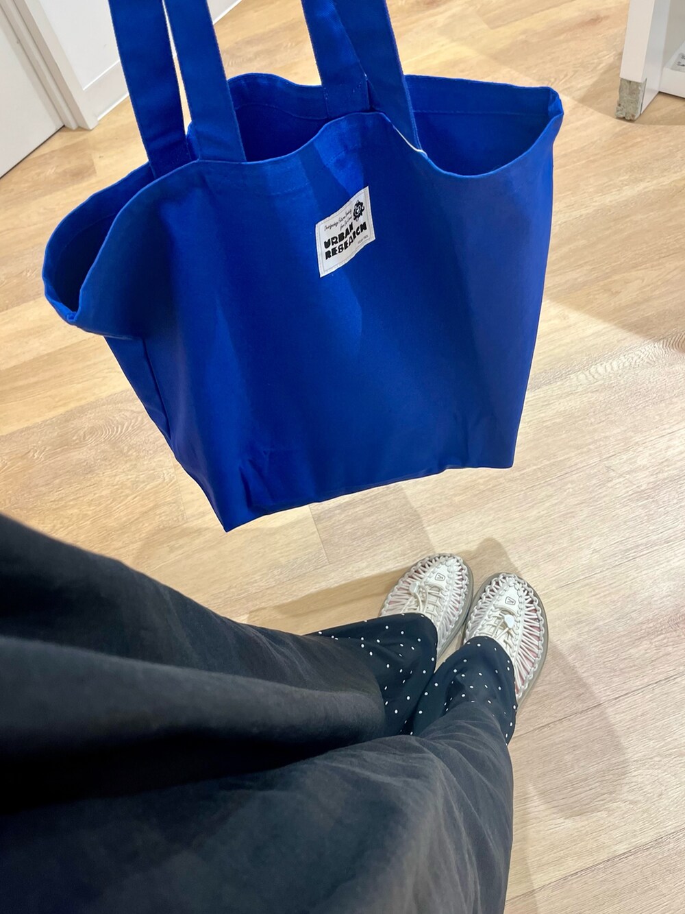 ブラック系のワンピース、ブルー系のトートバッグ、ブルー系のその他パンツを着用したレディースの夏コーディネートの6枚目の写真