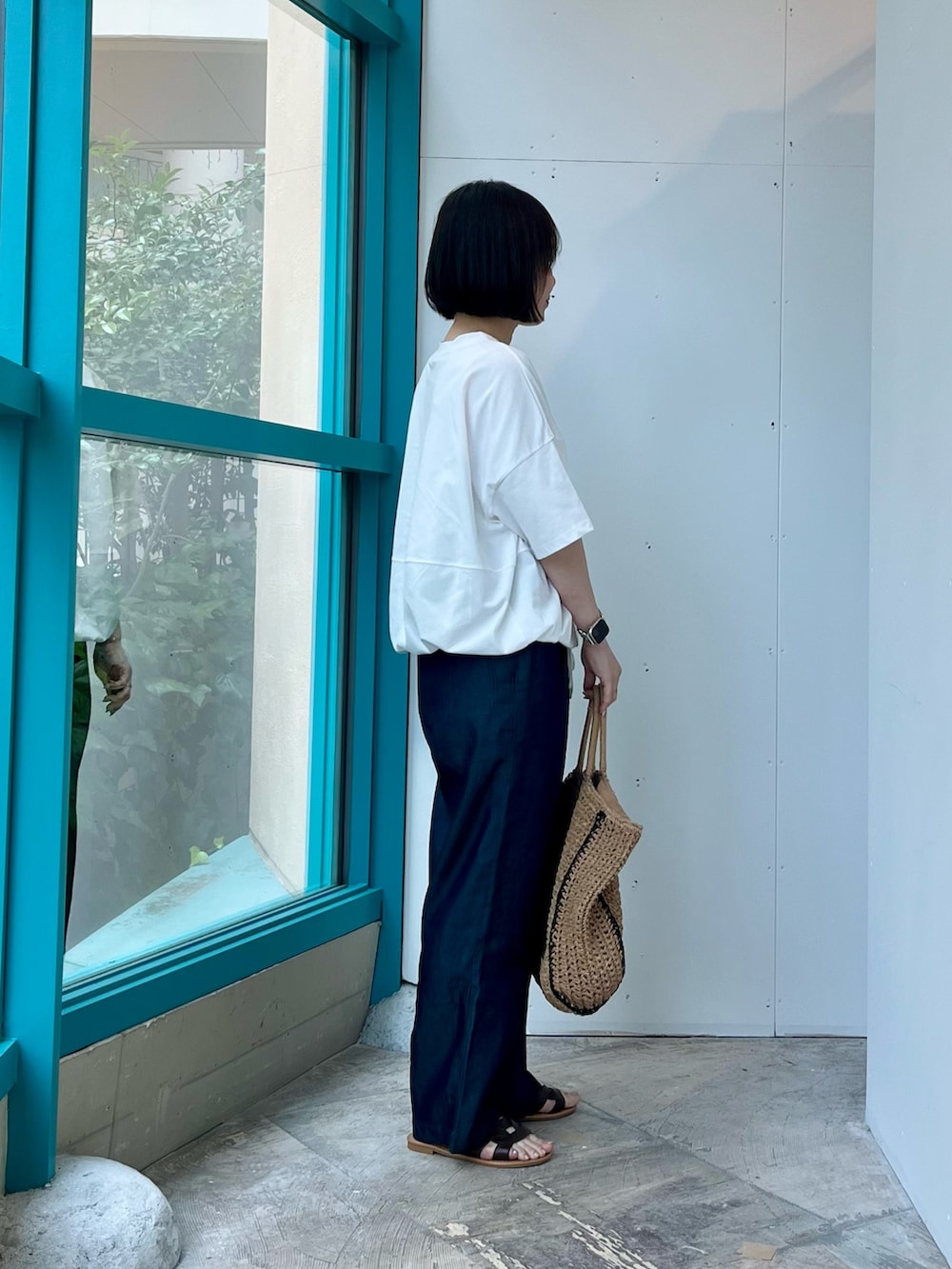 ホワイト系のTシャツ/カットソー、ブルー系のデニムパンツ、ベージュ系のトートバッグを着用したレディースの夏コーディネートの3枚目の写真
