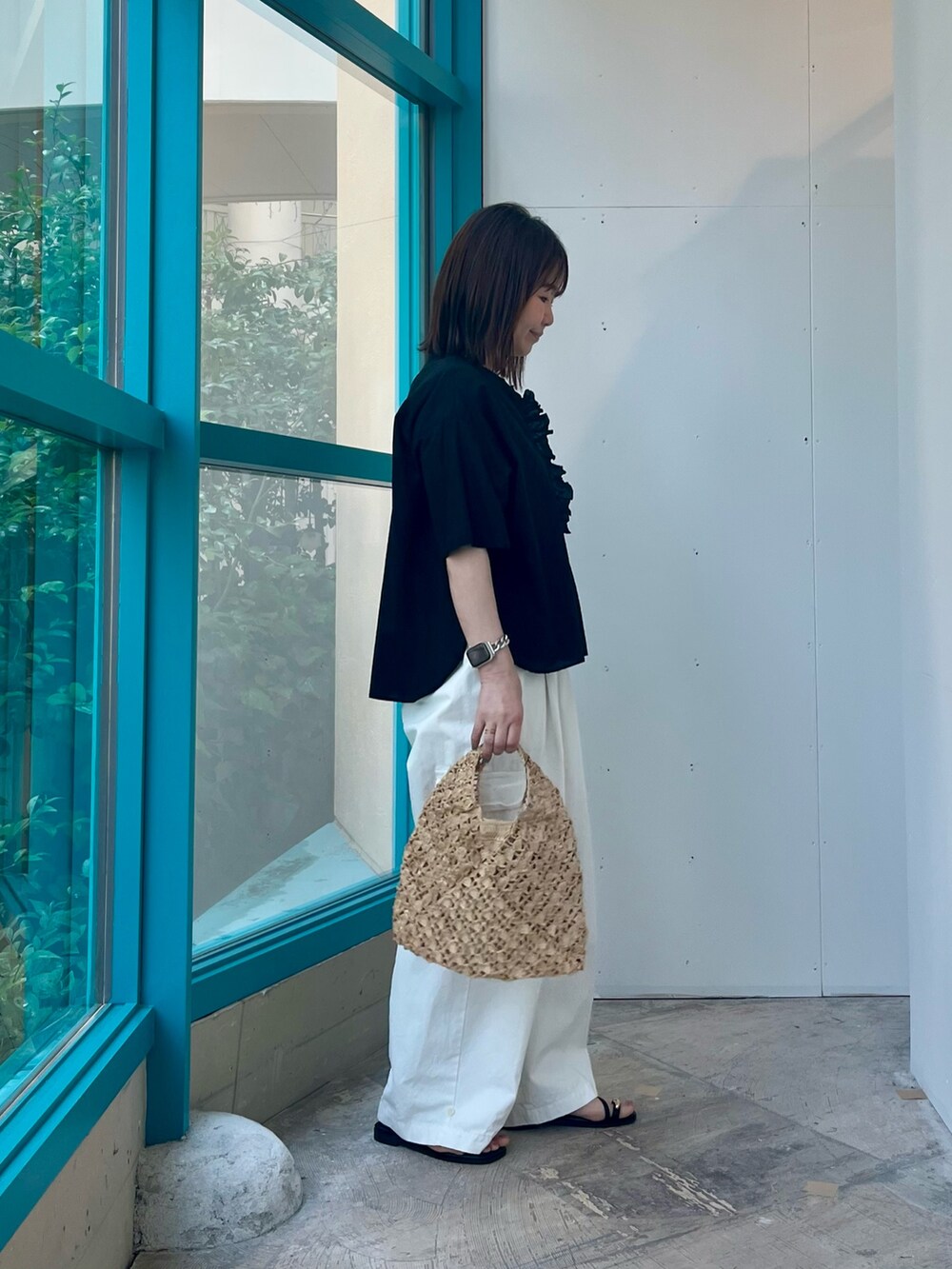 ブラック系のシャツ/ブラウス、ホワイト系のその他パンツ、ベージュ系のハンドバッグを着用したレディースの夏コーディネートの2枚目の写真
