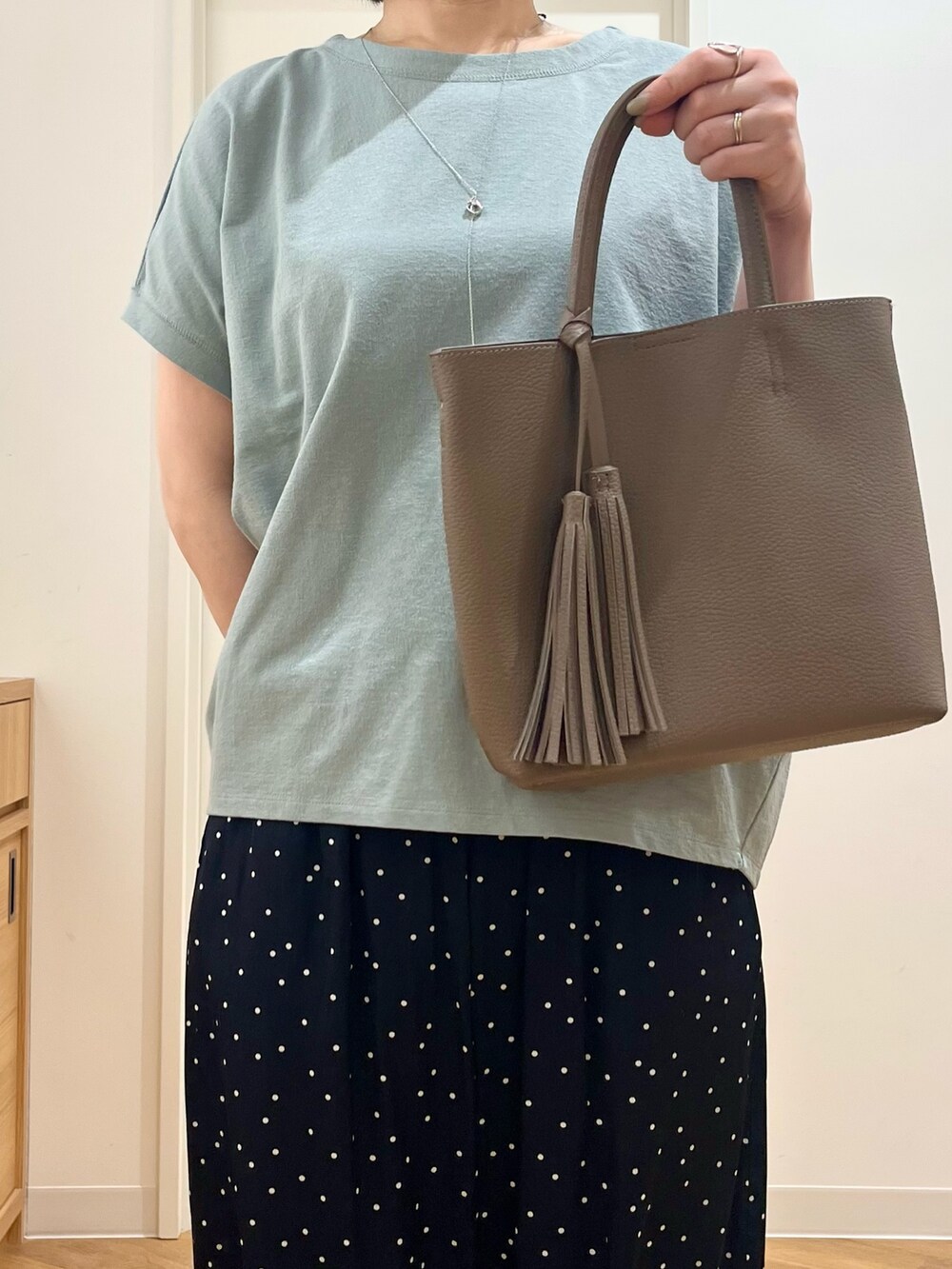 グレー系のトートバッグ、グリーン系のTシャツ/カットソー、ブルー系のその他パンツを着用したレディースの夏コーディネートの4枚目の写真