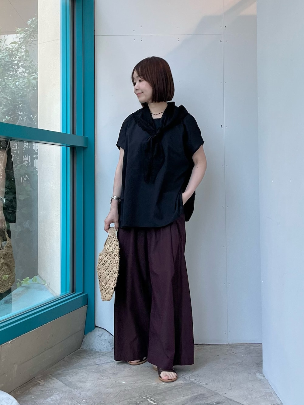 ブラック系のシャツ/ブラウス、ベージュ系のハンドバッグ、ブラウン系のその他パンツを着用したレディースの夏コーディネートの2枚目の写真