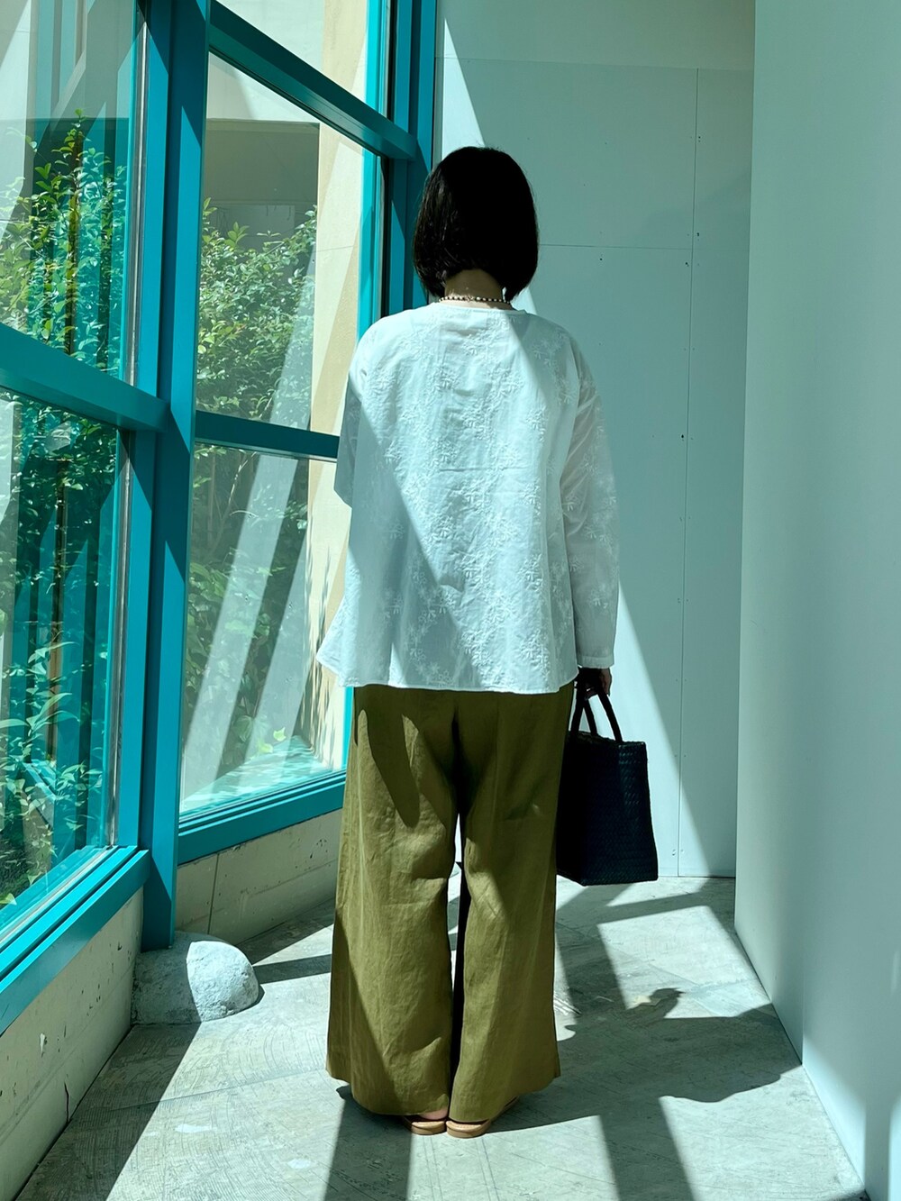 ホワイト系のシャツ/ブラウス、ベージュ系のその他パンツ、ブルー系のトートバッグを着用したレディースの夏コーディネートの3枚目の写真