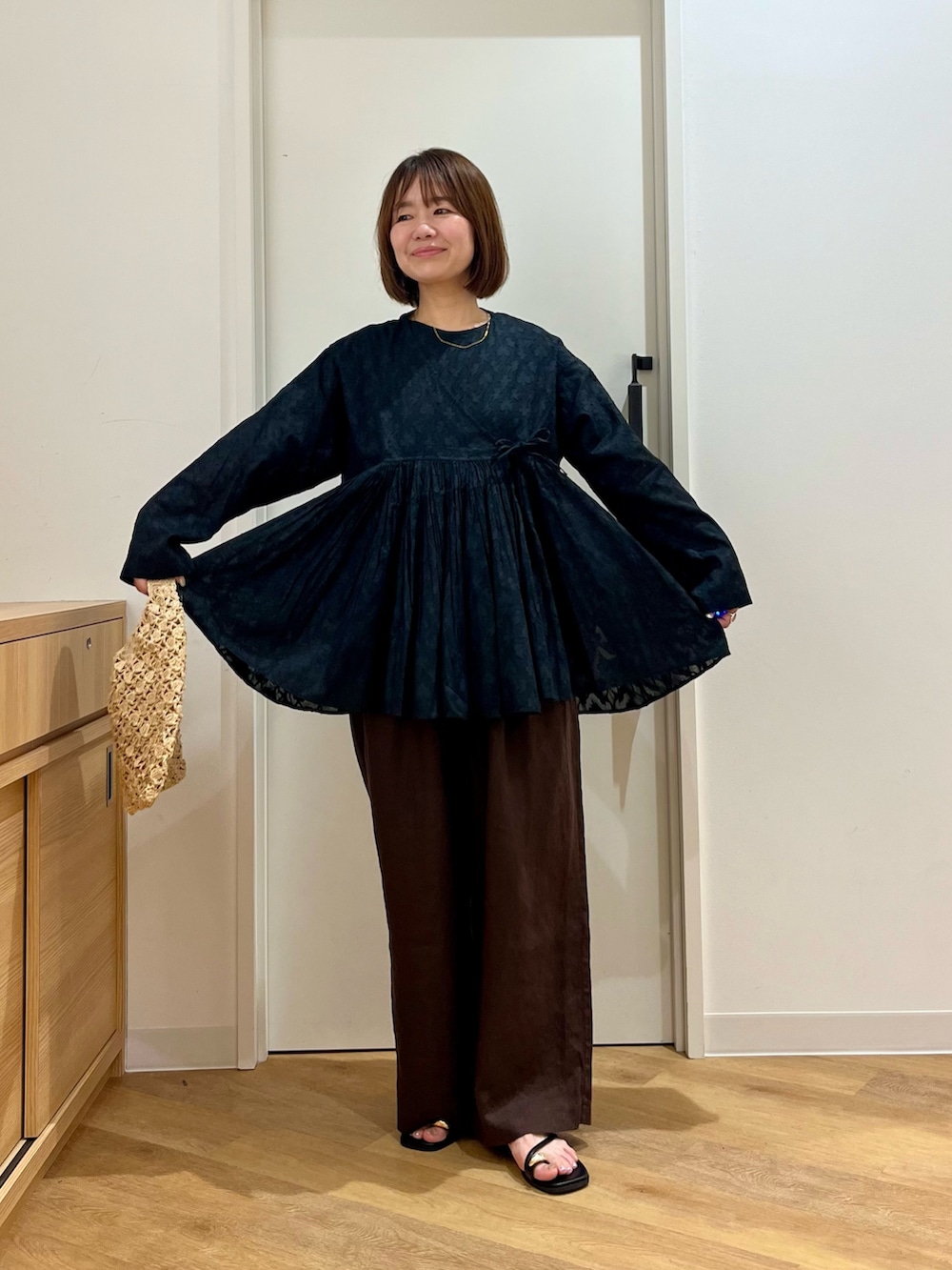 ブラック系のシャツ/ブラウス、ベージュ系のハンドバッグ、ブラウン系のその他パンツを着用したレディースの夏コーディネートの4枚目の写真